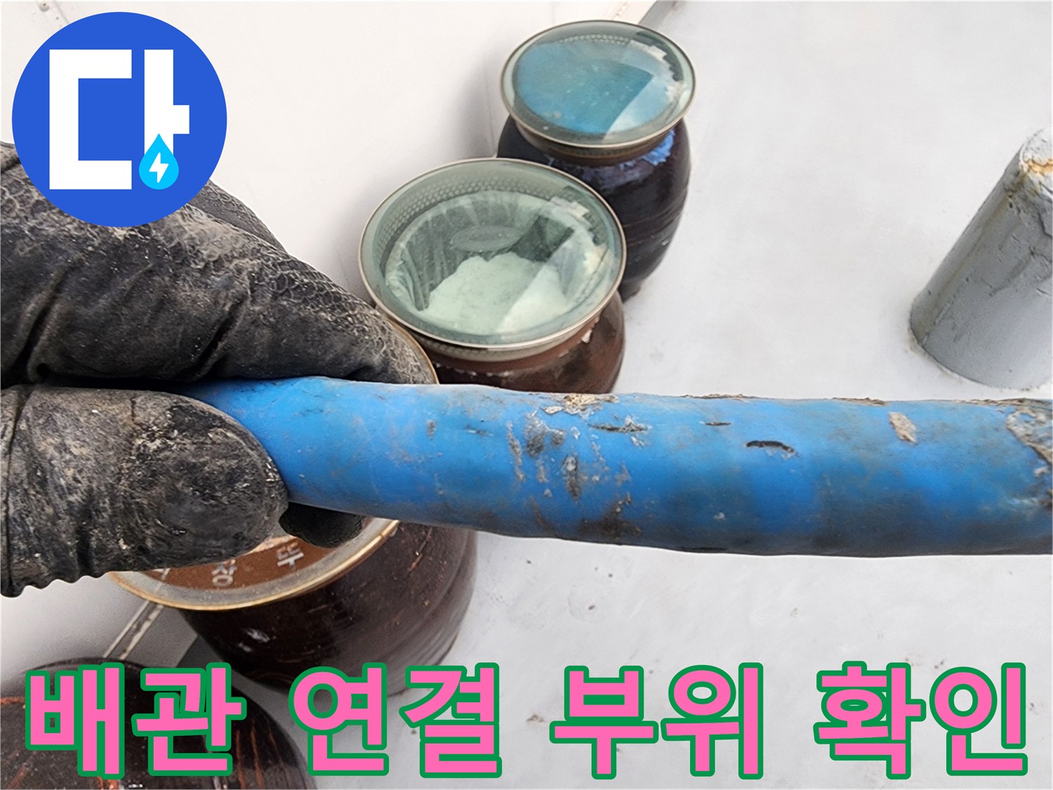 누수 진단을 위해 파란색 배관의 겉면과 주변 부속을 세밀하게 관측하는 모습입니다.