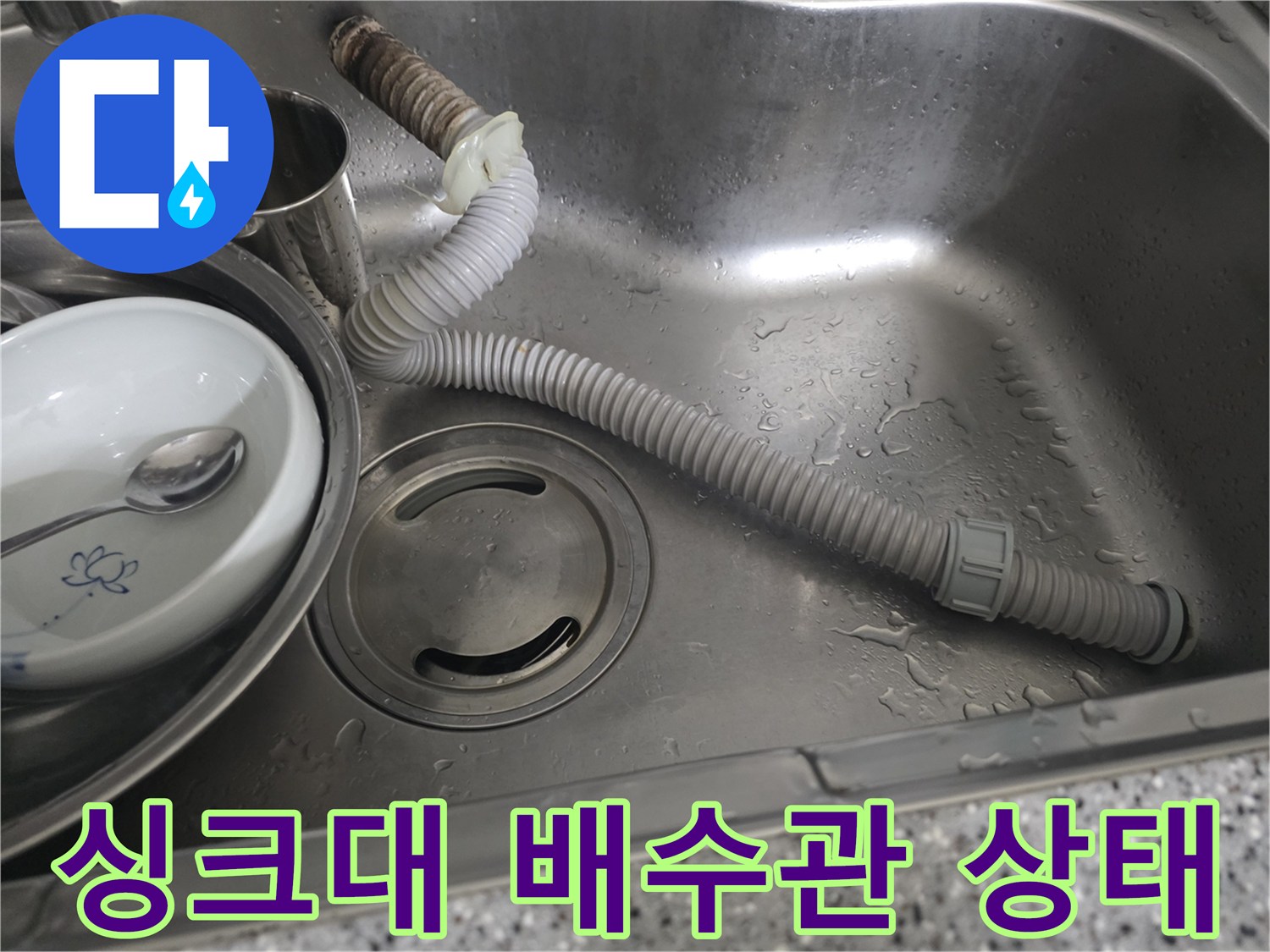 싱크대 볼 내부의 젖어있는 배수 호스와 금속 부속품 사진