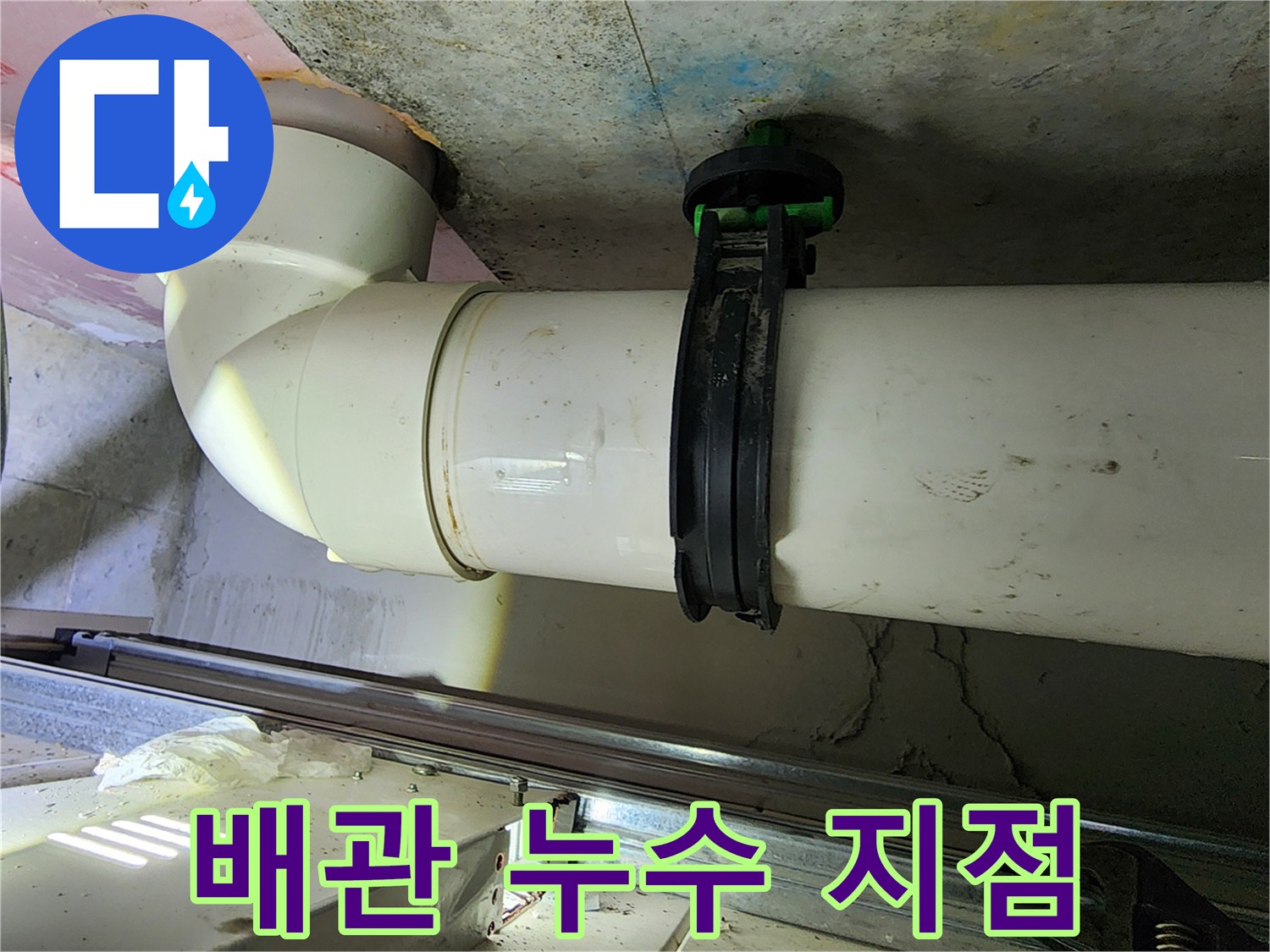 천장에 설치된 하얀색 PVC 관과 검은색 고정 부속 사진입니다.