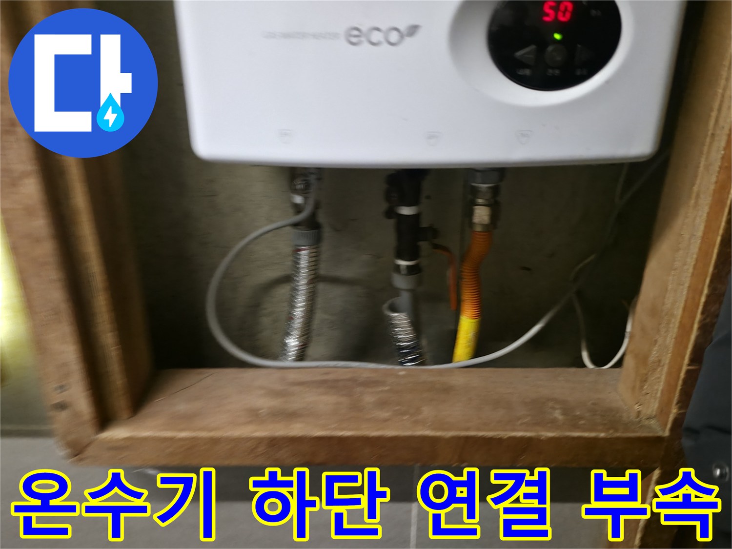 전기 온수기 - 아래로 연결된 은색 주름관과 노란 호스
