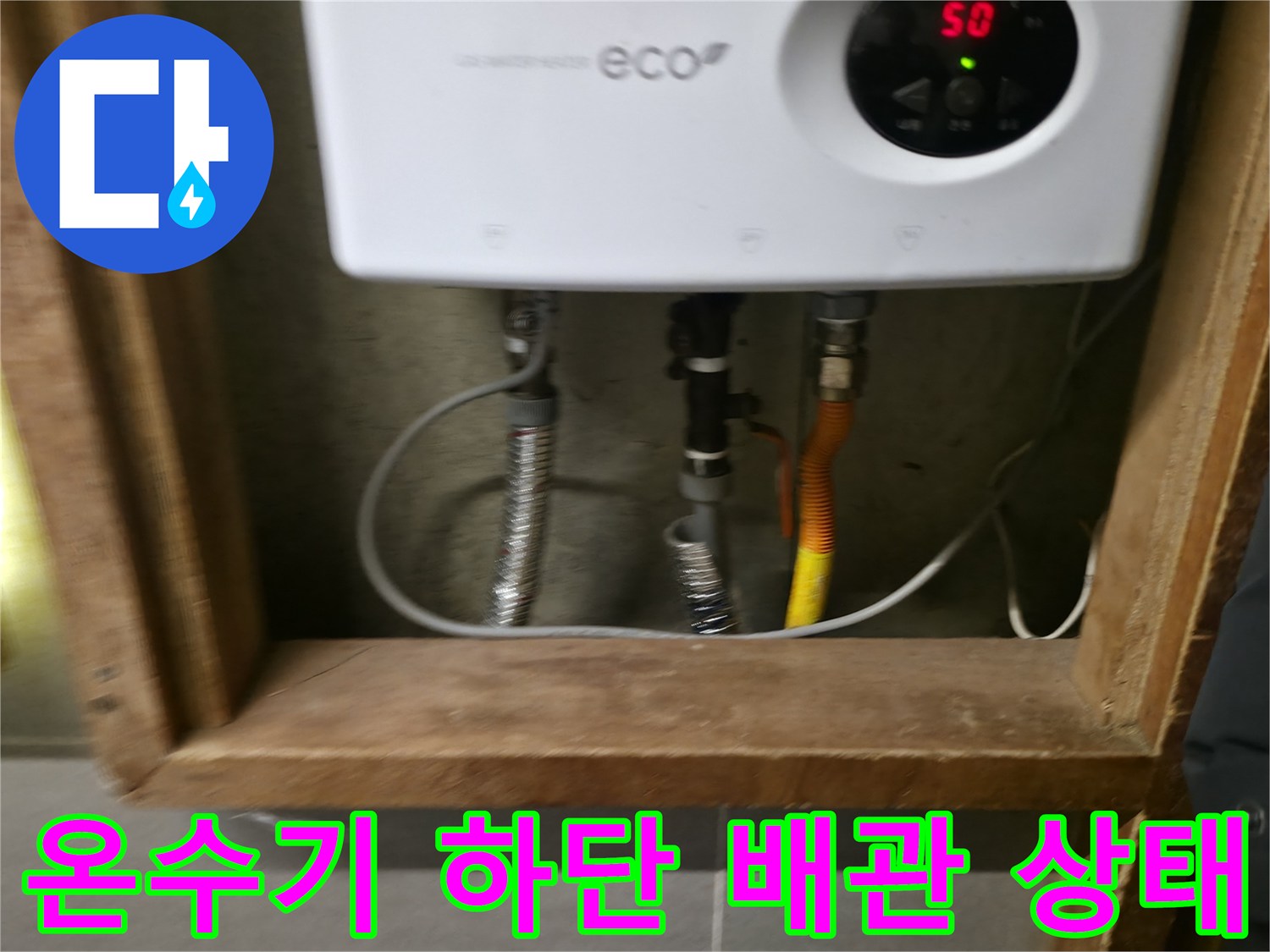 전기 온수기와 연결된 하단 배관 및 주름관 근접 사진