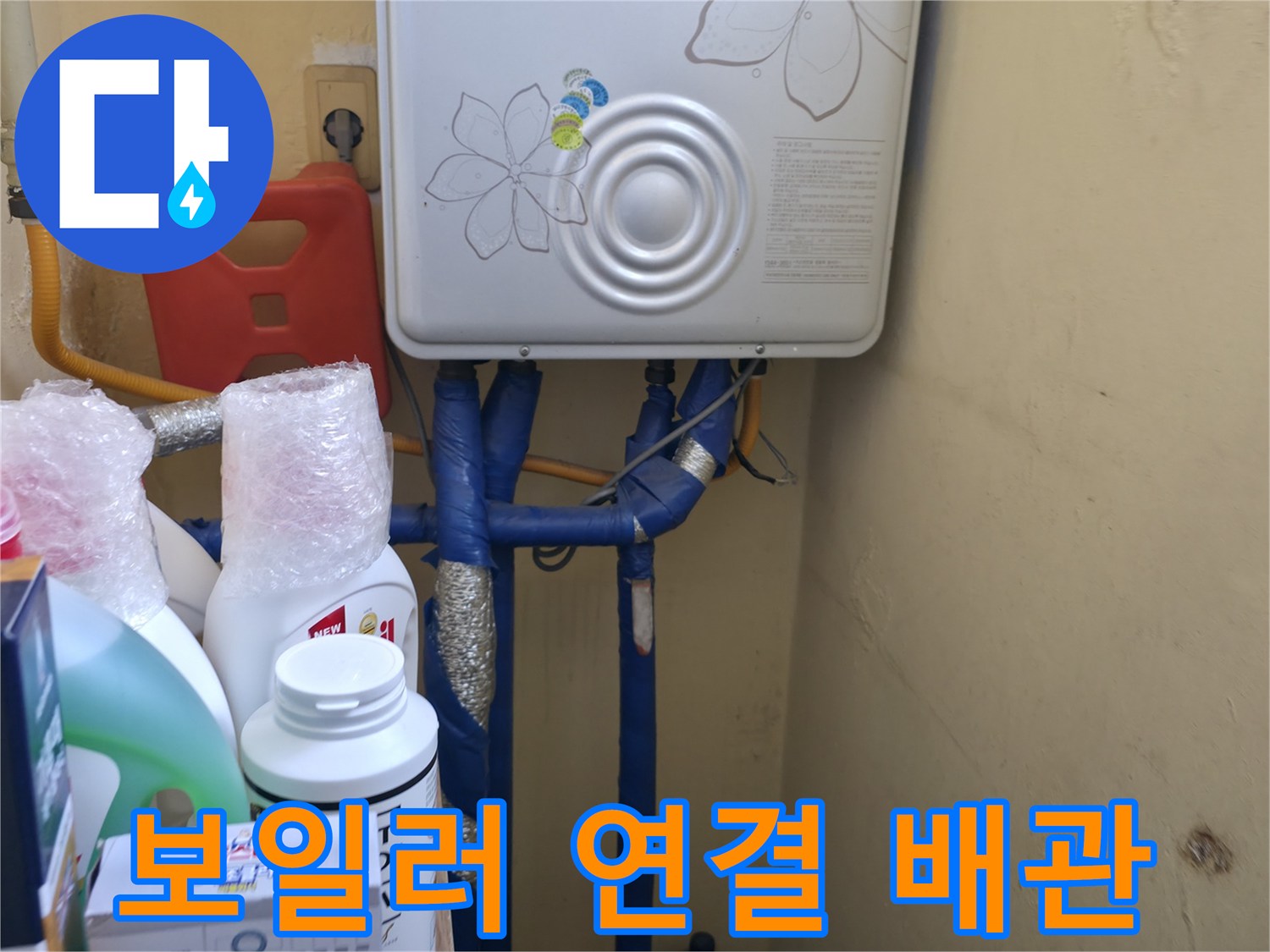 보일러 하단에 위치한 파란색 및 노란색 배관 구조 - 누수 점검 중인 현장 사진입니다.