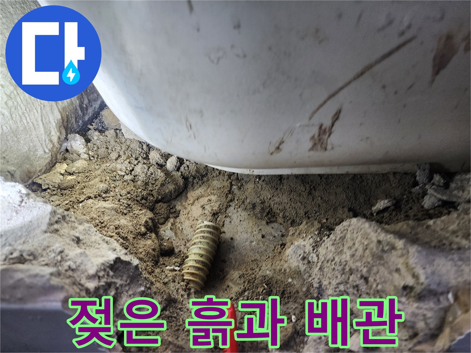 물이 새어 나와 축축하게 젖은 흙 속에 노출된 파손 배관입니다.