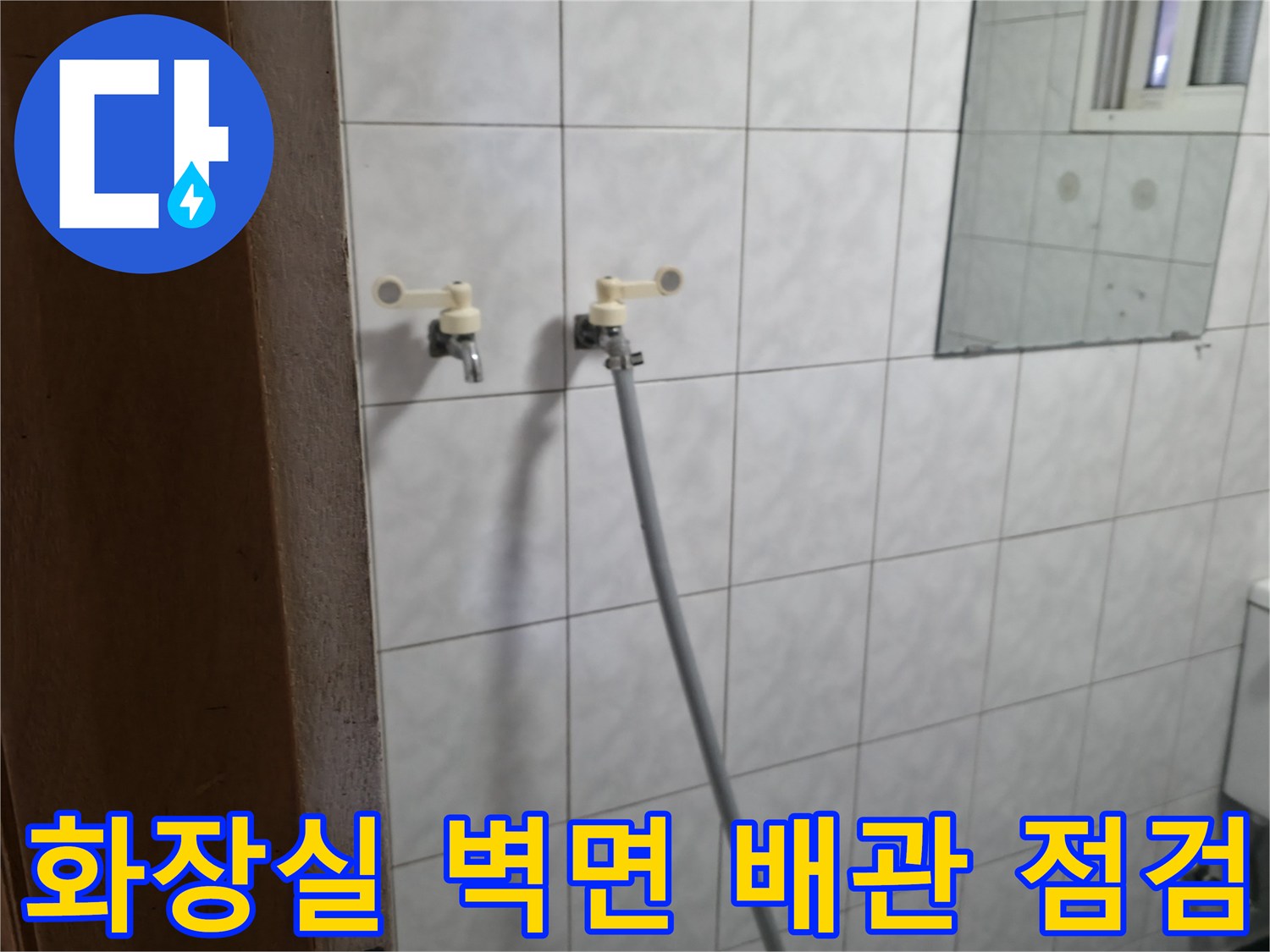 흰색 타일 벽에 설치된 수전과 호스 연결부