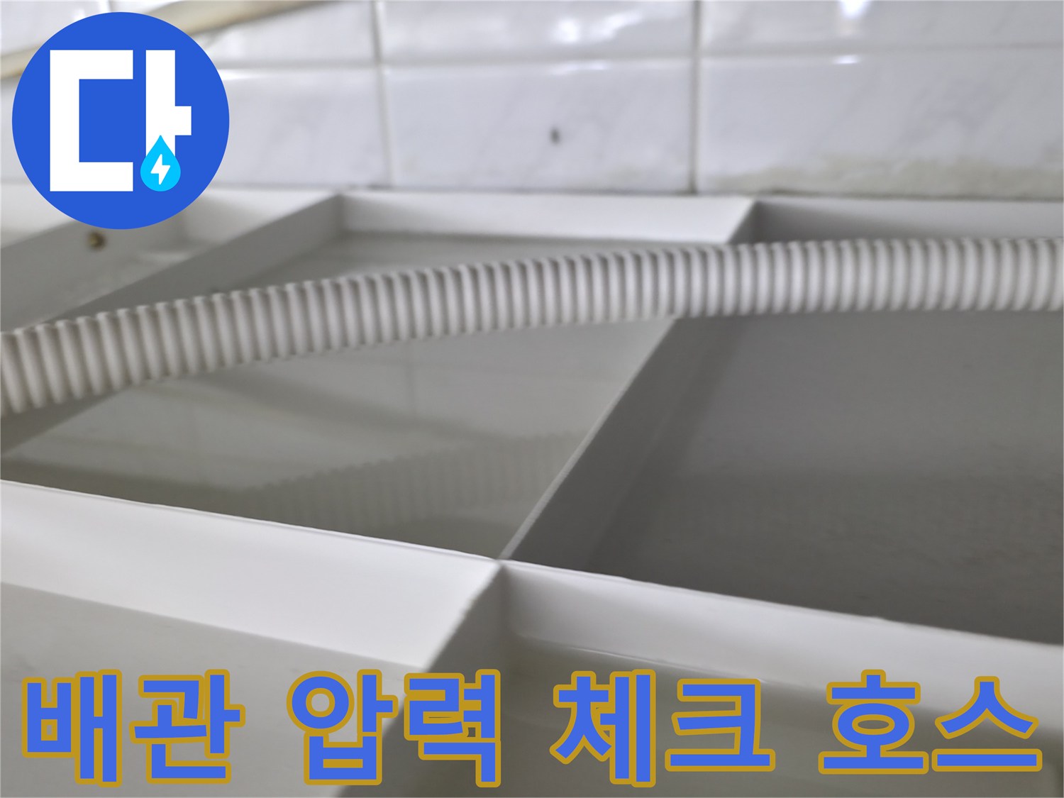 하얀색 배관 프레임에 연결된 굴곡진 검사용 호스