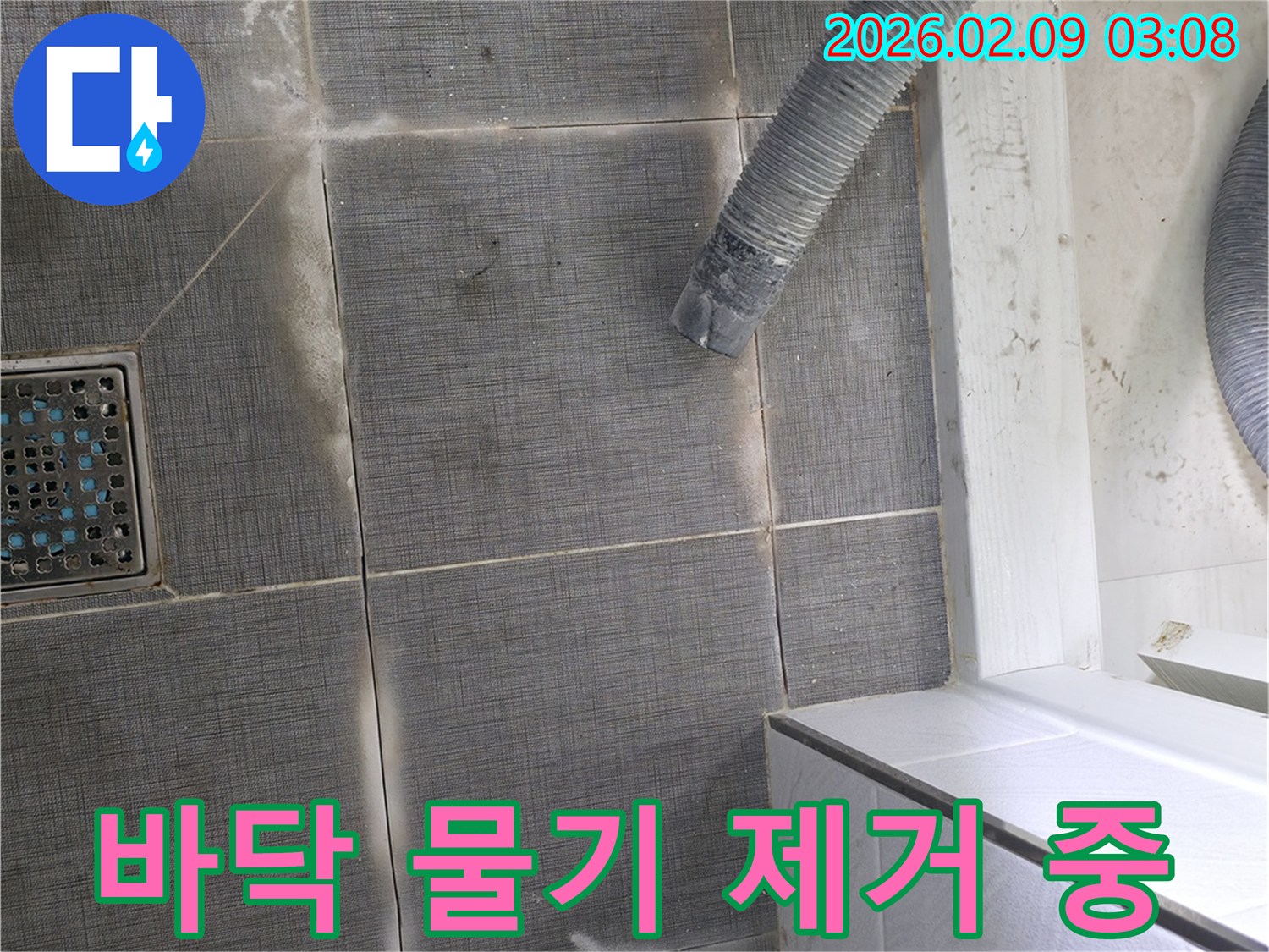 누수 공사 현장에서-바닥 타일 위에 놓인 건조용 호스-배관 누수 탐지 후 건조 작업 진행 중