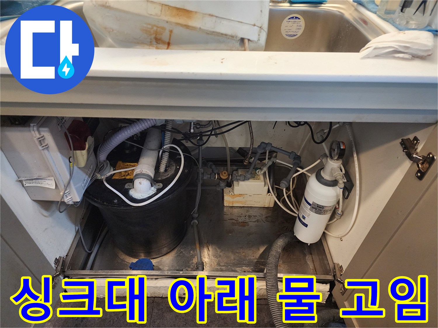 싱크대 하단 바닥의 물고임 현상과 주변 배관 구조를 보여주는 사진