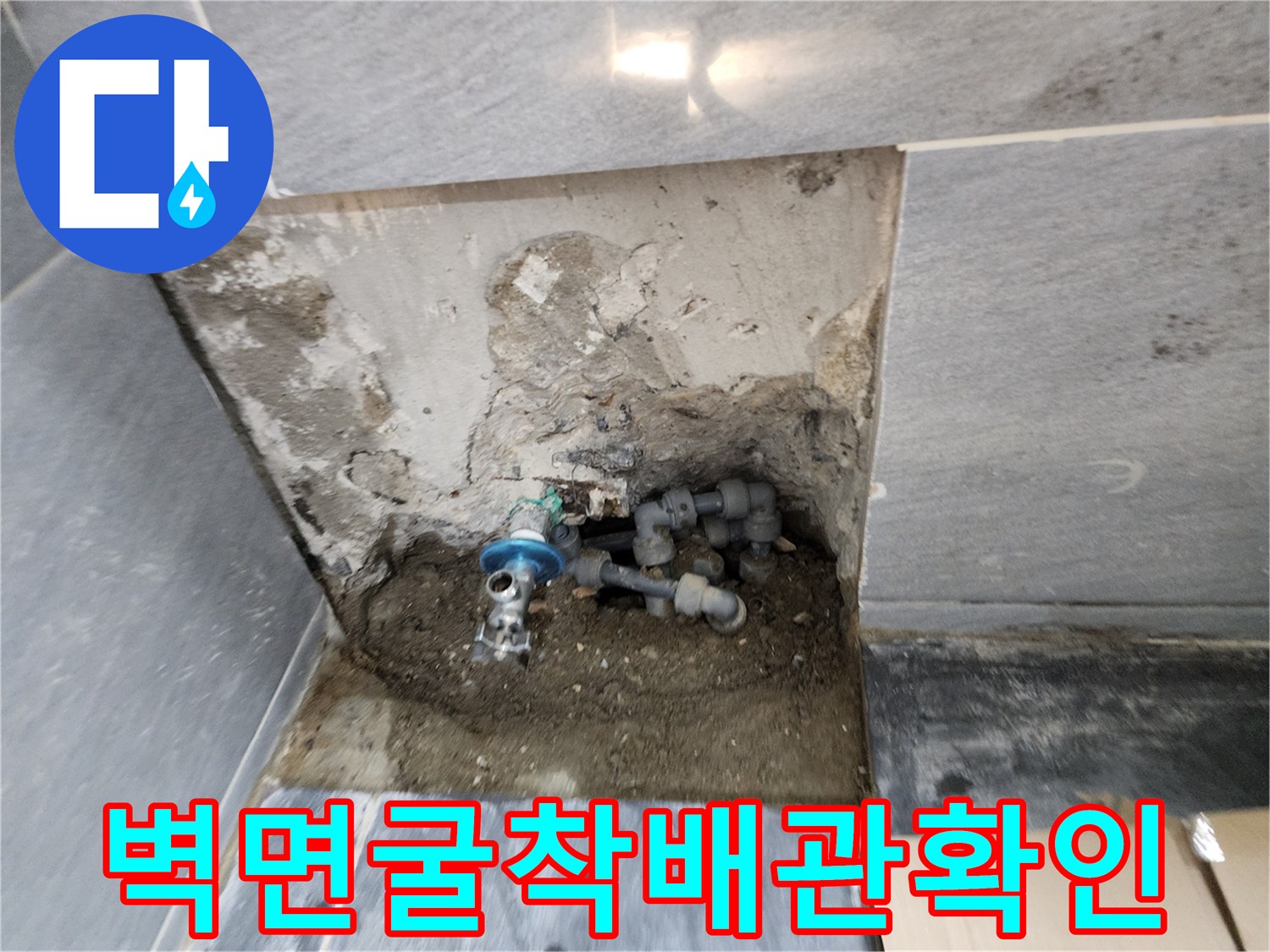 타일 제거 후 드러난 젖은 벽면과 배관 연결부