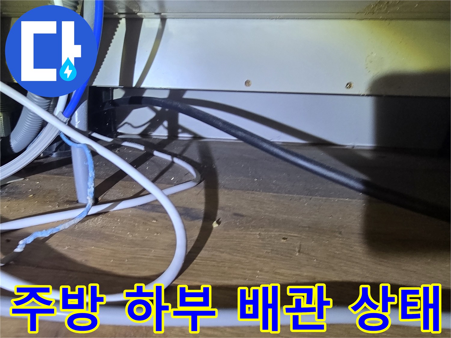 싱크대 밑부분의 다양한 호스와 전선류 복합 연결 부위