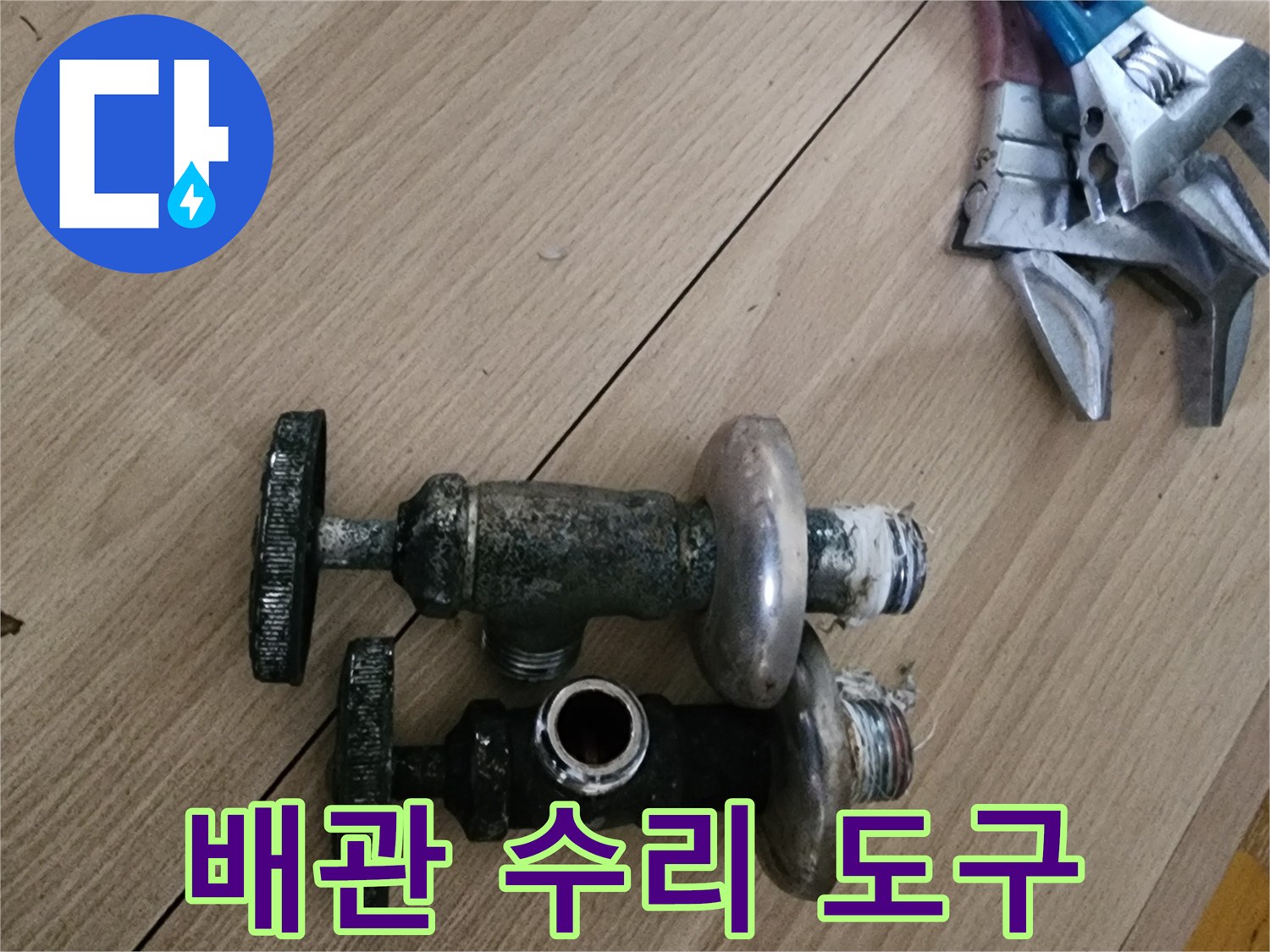 수도 부속과 공구가 놓인 작업 현장 사진
