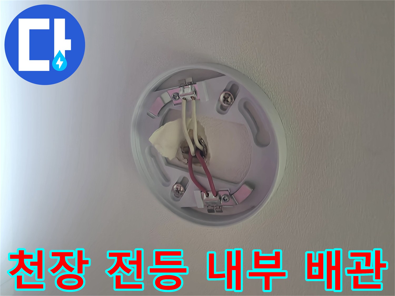 천장 조명 기구 내부의 노출된 전선과 배관 상태를 보여주는 사진