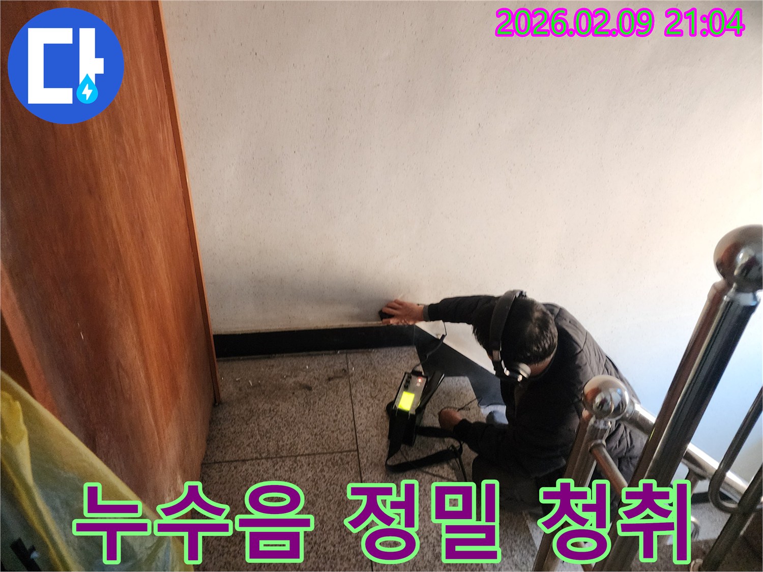 전문-기술자가-누수-탐지기를-사용하여-건물-내부의-미세한-물샘-소리를-집중적으로-듣고-있는-장면
