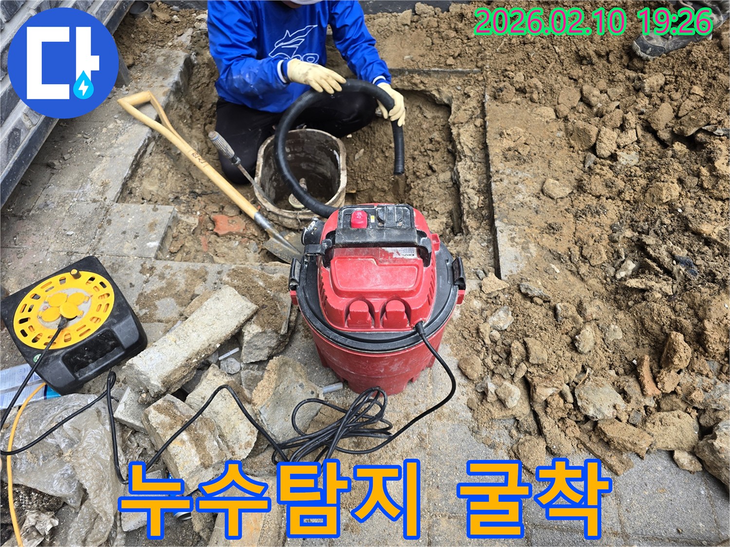 누수 공사를 위해 땅을 파고-진공 흡입기로 흙을 제거하는-작업자의 모습입니다.