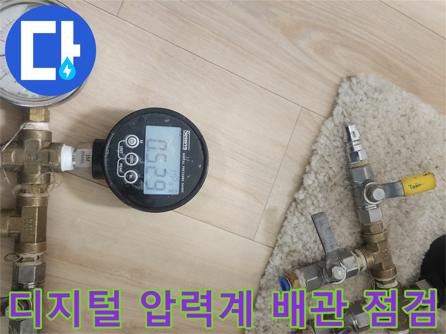 아파트 천장 분배기 부근에서 진행 중인 디지털 압력계 배관 기밀 테스트 상황
