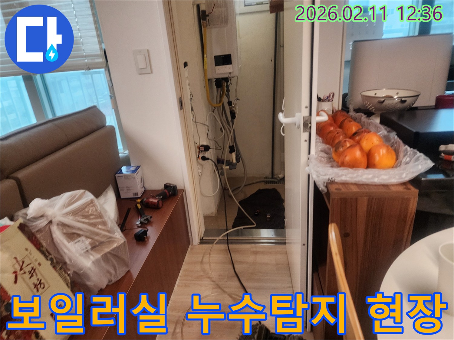 이 이미지는 주거 공간의 보일러실에서 진행된 누수 탐지 작업 현장을 보여줍니다-전문가가 장비를 사용하여 배관 문제를 확인하고 있습니다.