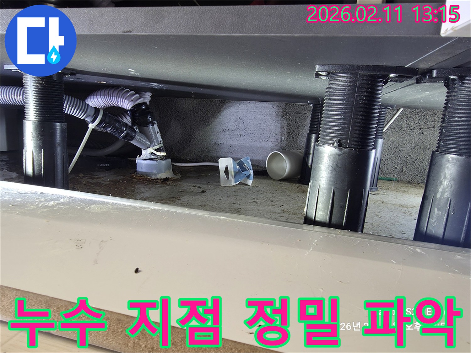 싱크대 하부 배수관 주변에서 발생한 누수의 정확한 지점을-전문 엔지니어가 면밀히 파악하고 있는 현장 사진