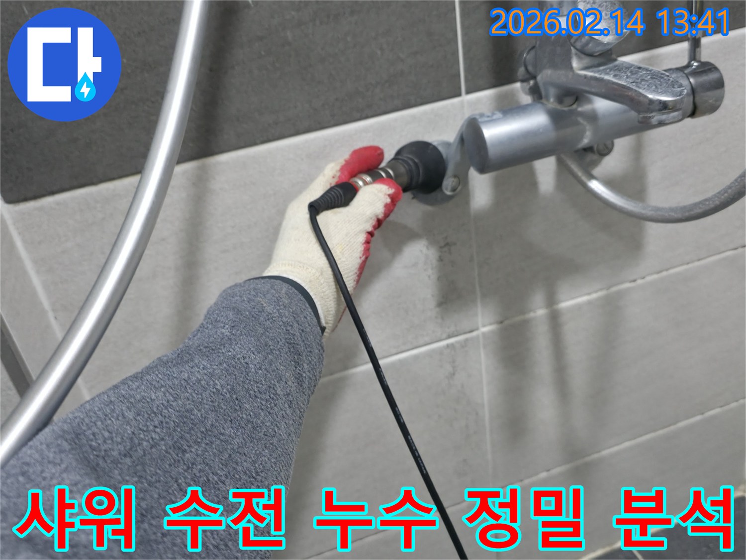 누수 엔지니어가-장갑을 낀 손으로-샤워 수전에-탐지 장비를 연결하여-누수 원인을 정밀 분석하고 있습니다