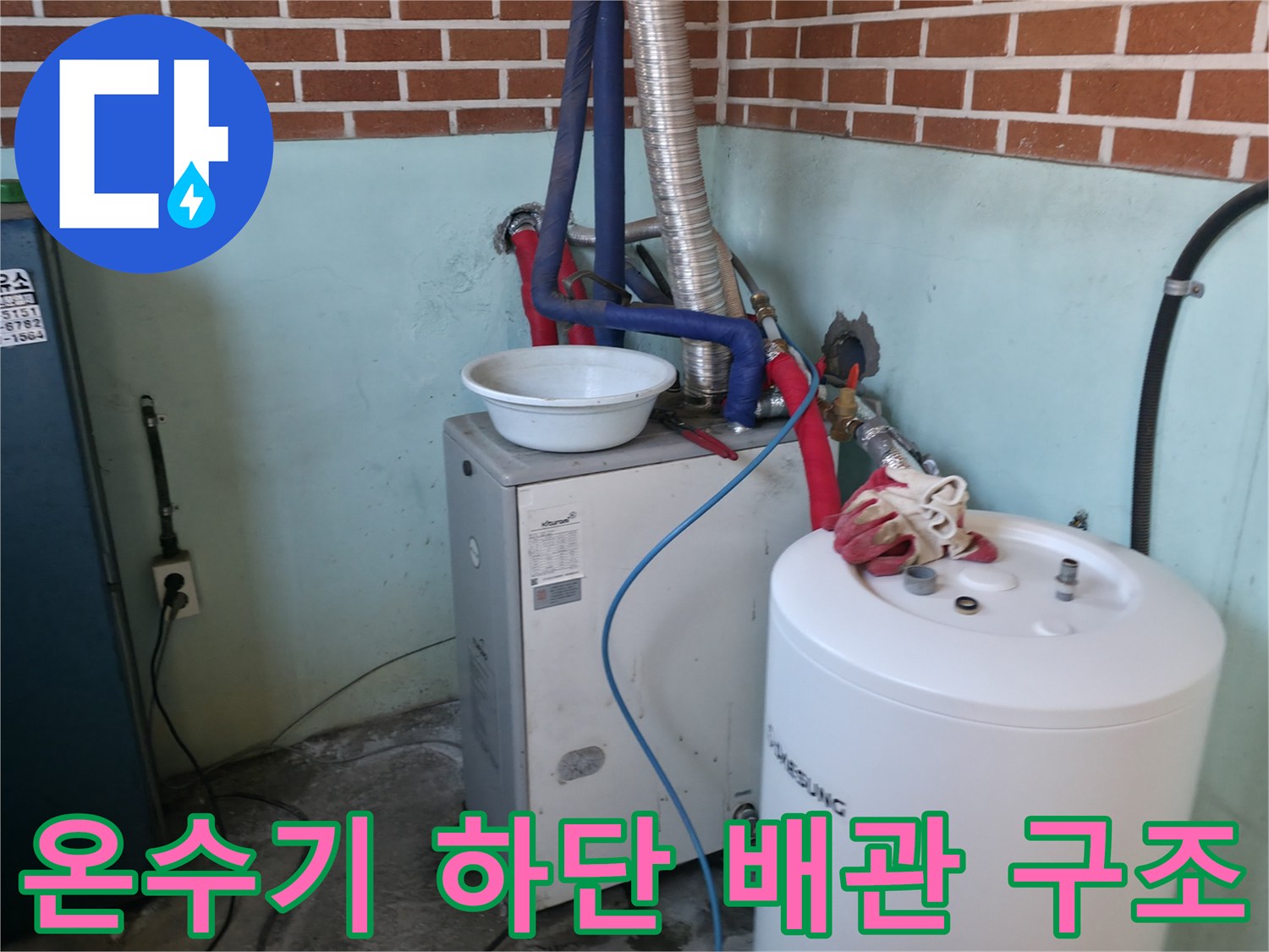 주방 벽면 배관 시설-은색 주름관과 온수기 연결 부위 모습