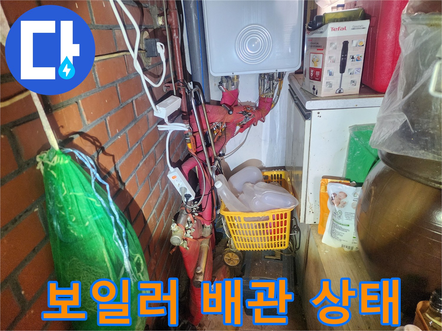 다용도실 내부에 설치된-붉은색 보온재가 감긴 배관들