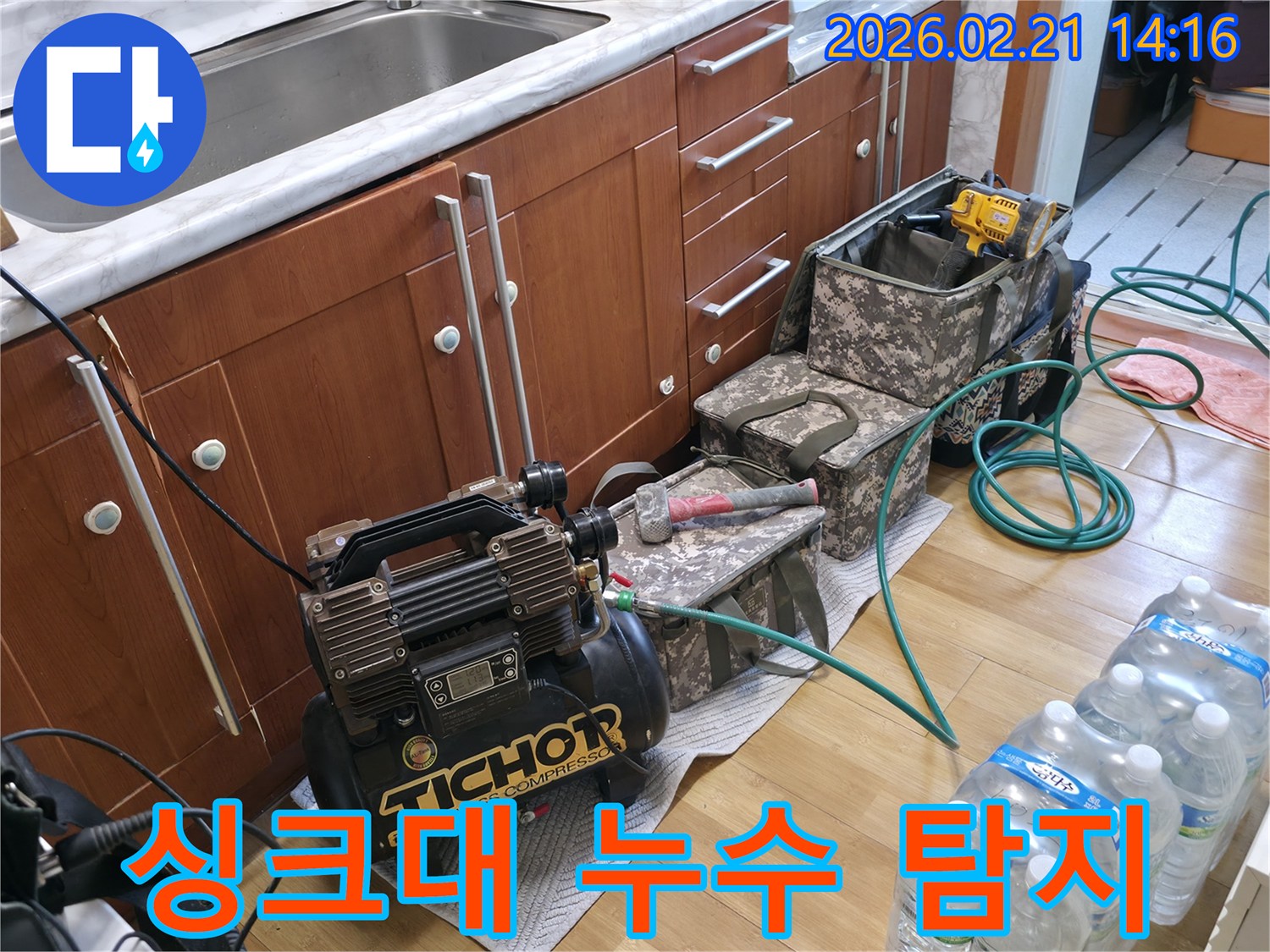 싱크대-아래 공간에-누수-탐지 장비인-압축기를-설치하고-작업을 준비하는-모습
