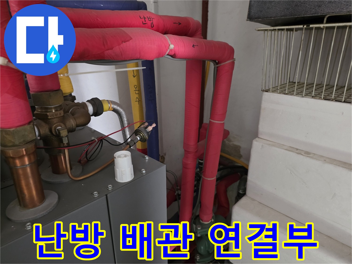 보온재로 감싸진 붉은색 배관과 금속 연결 부품의 상세 사진