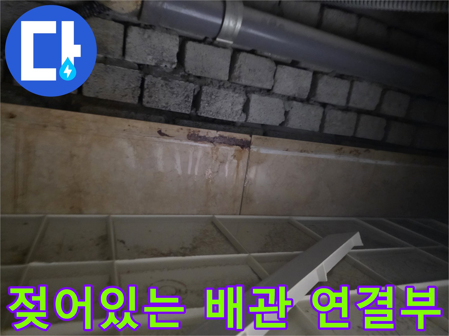 습기로 오염된 천장 배관과 노출된 벽돌 구조