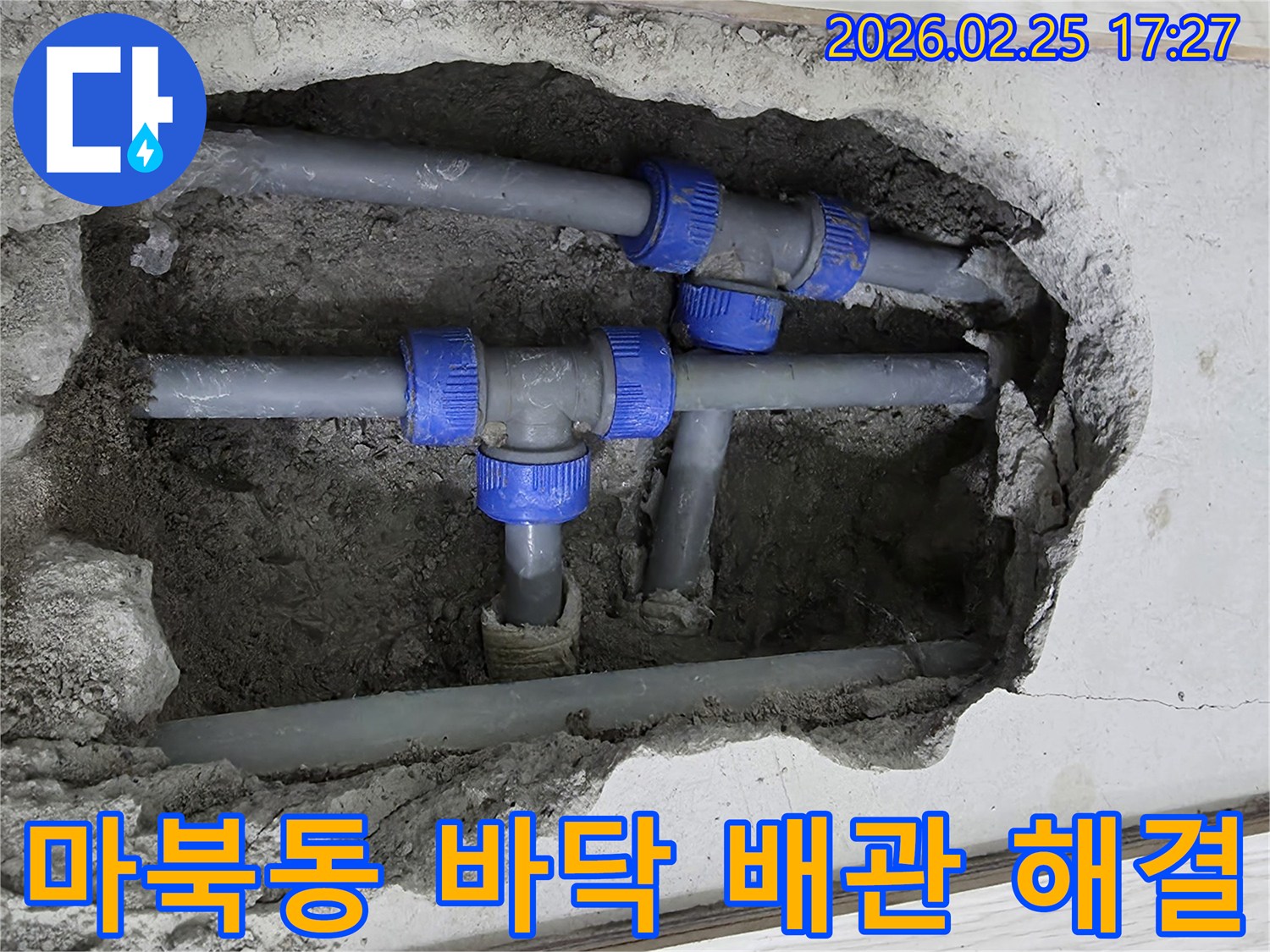 콘크리트 바닥을 파내어 드러난-파란색 연결 부속이 있는 회색 배관들-누수 문제를 해결하기 위한 작업 현장