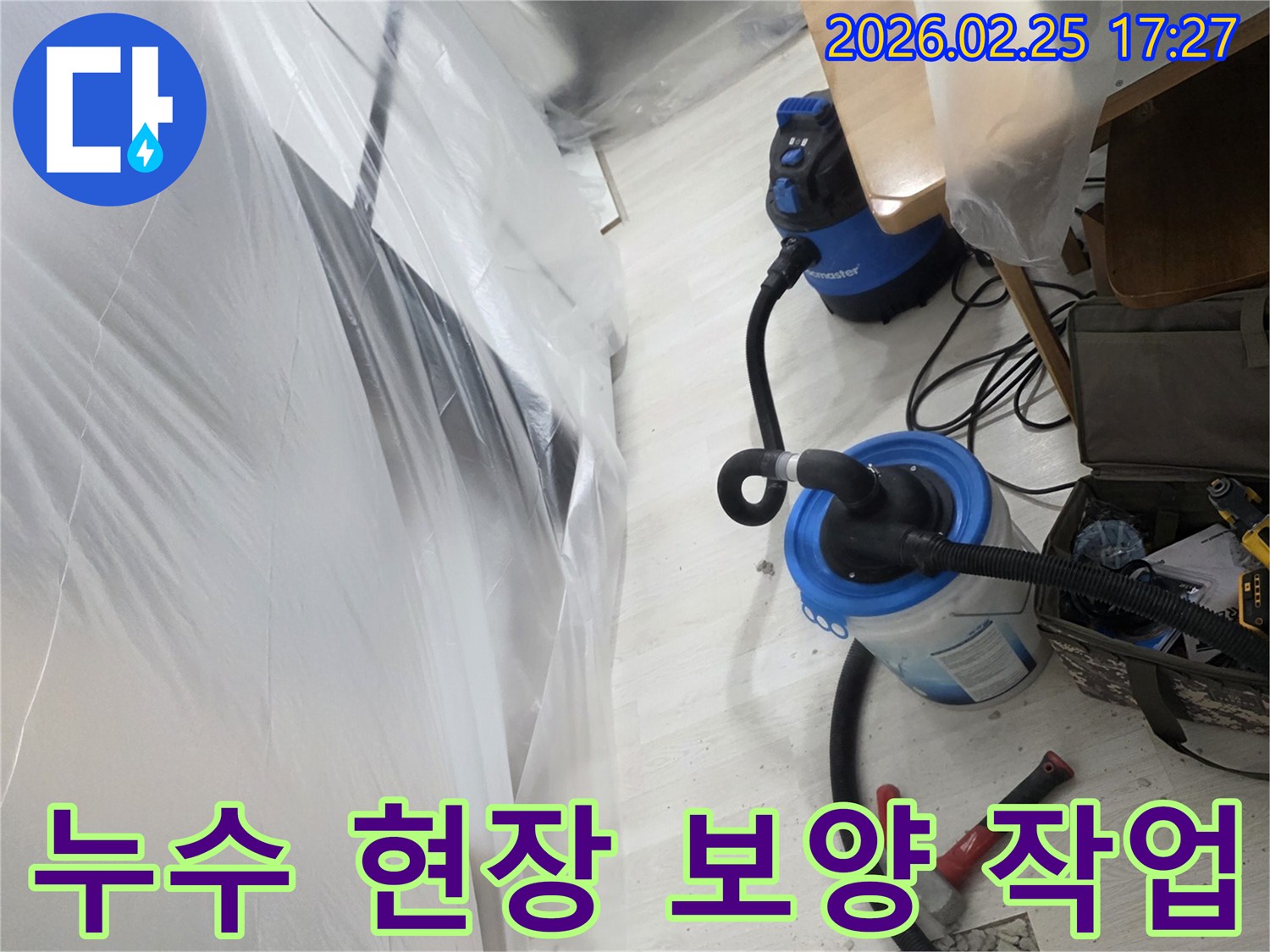 투명 비닐로 보양된 공간에서-누수 탐지 및-건조 작업이 진행 중인-사진입니다