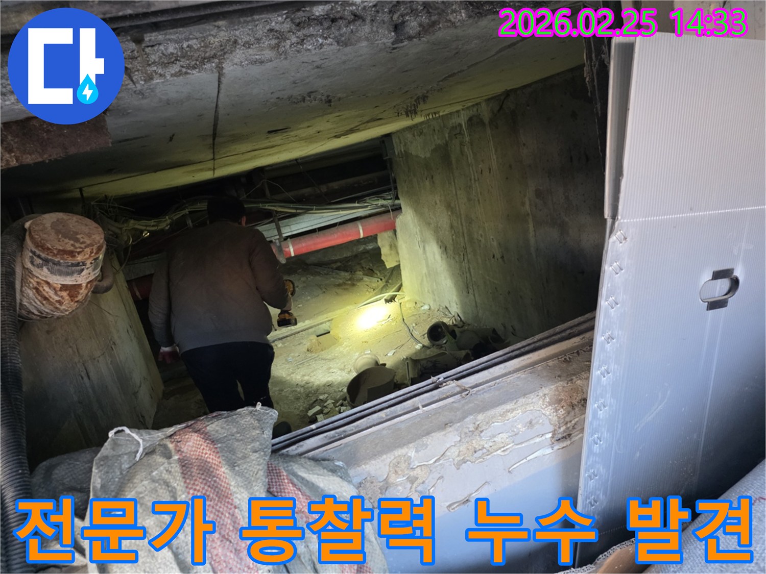누수 전문 엔지니어가-어둡고 좁은 공간에서-손전등을 비춰가며-전문가의 통찰력으로-누수 지점을 정확히-발견하는 모습입니다.