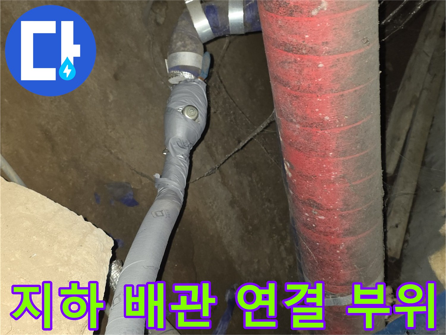 붉은색 보온재와 은색 마감 테이프가 사용된 지하 배관 시설