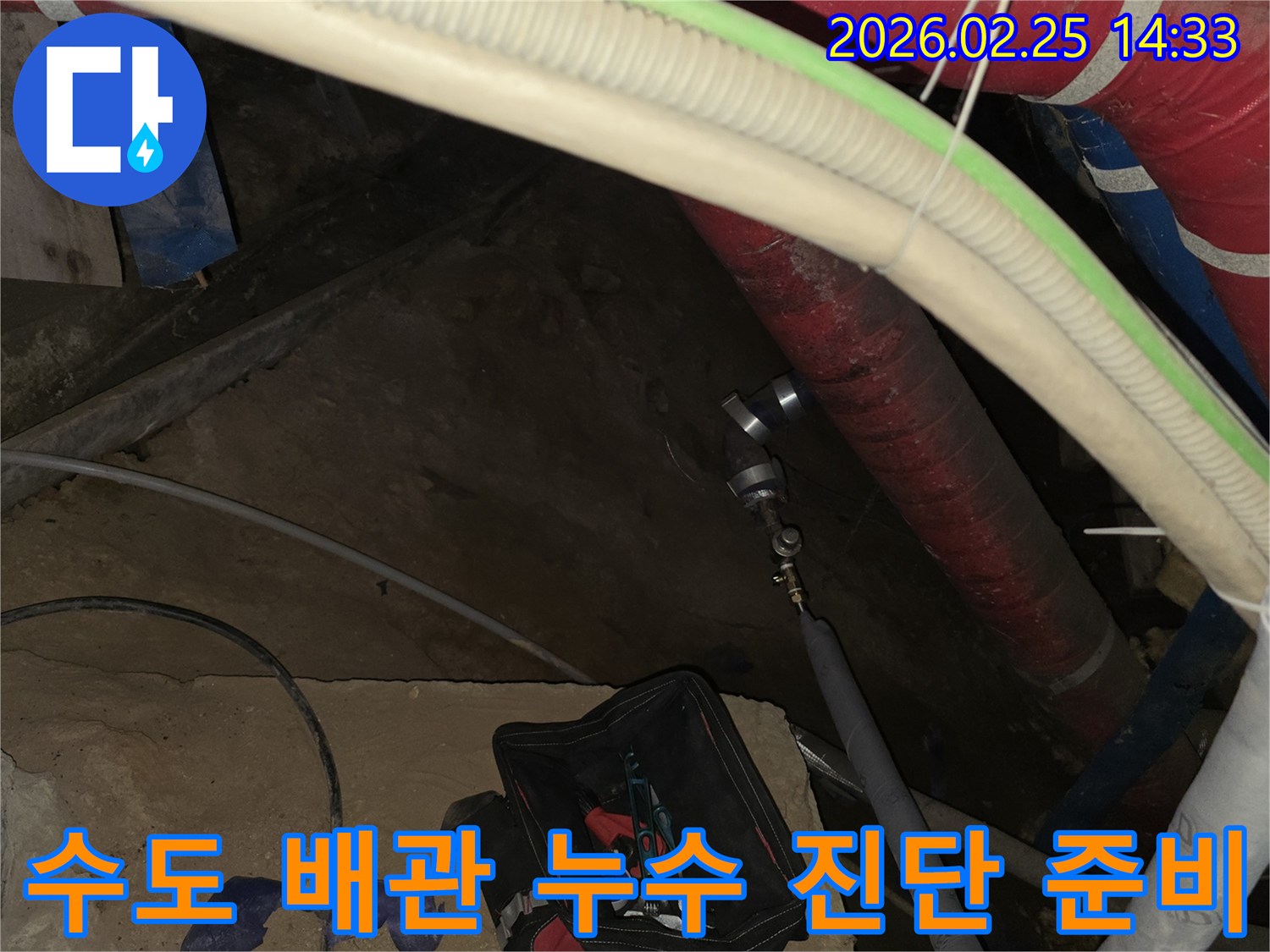 수도 배관에서 발생하는 누수 소리와-물 낭비를 멈추기 위해-전문 탐지 장비를 연결하여-정밀 검사를 진행하는 현장입니다.