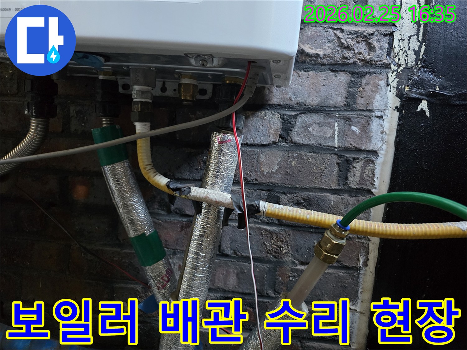 이 이미지는-벽에 설치된-보일러 하단부의-복잡한 배관 연결부와-전선-그리고-은색 단열재로-감싸진-파이프들을-보여주며-누수 수리를 위한-정밀한 점검이-진행되고-있음을-암시합니다.