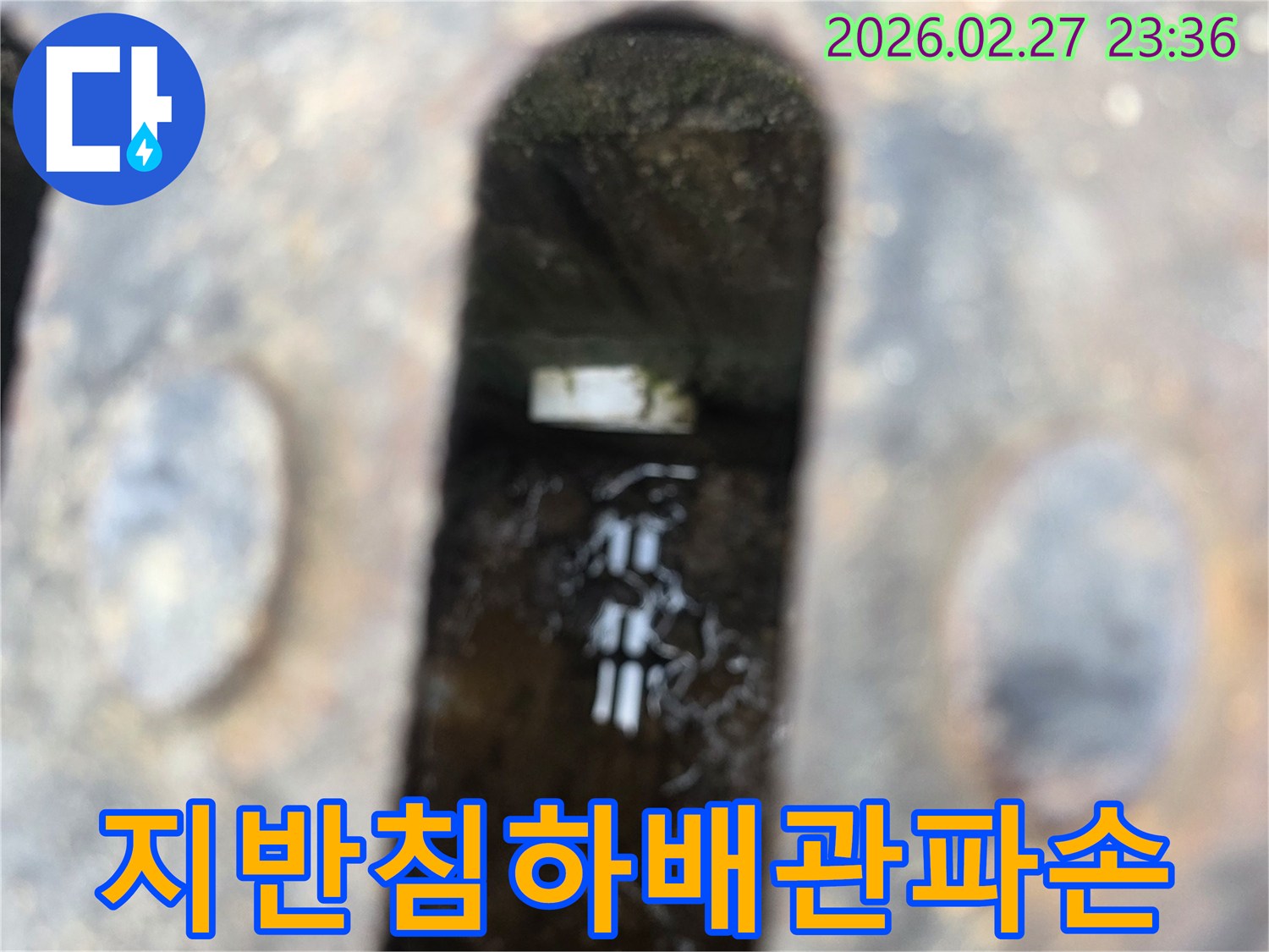 녹슨-철제-덮개-아래-고인-물과-물속에-잠긴-지반-침하로-파손된-듯한-배관-조각이-보이는-누수-현장