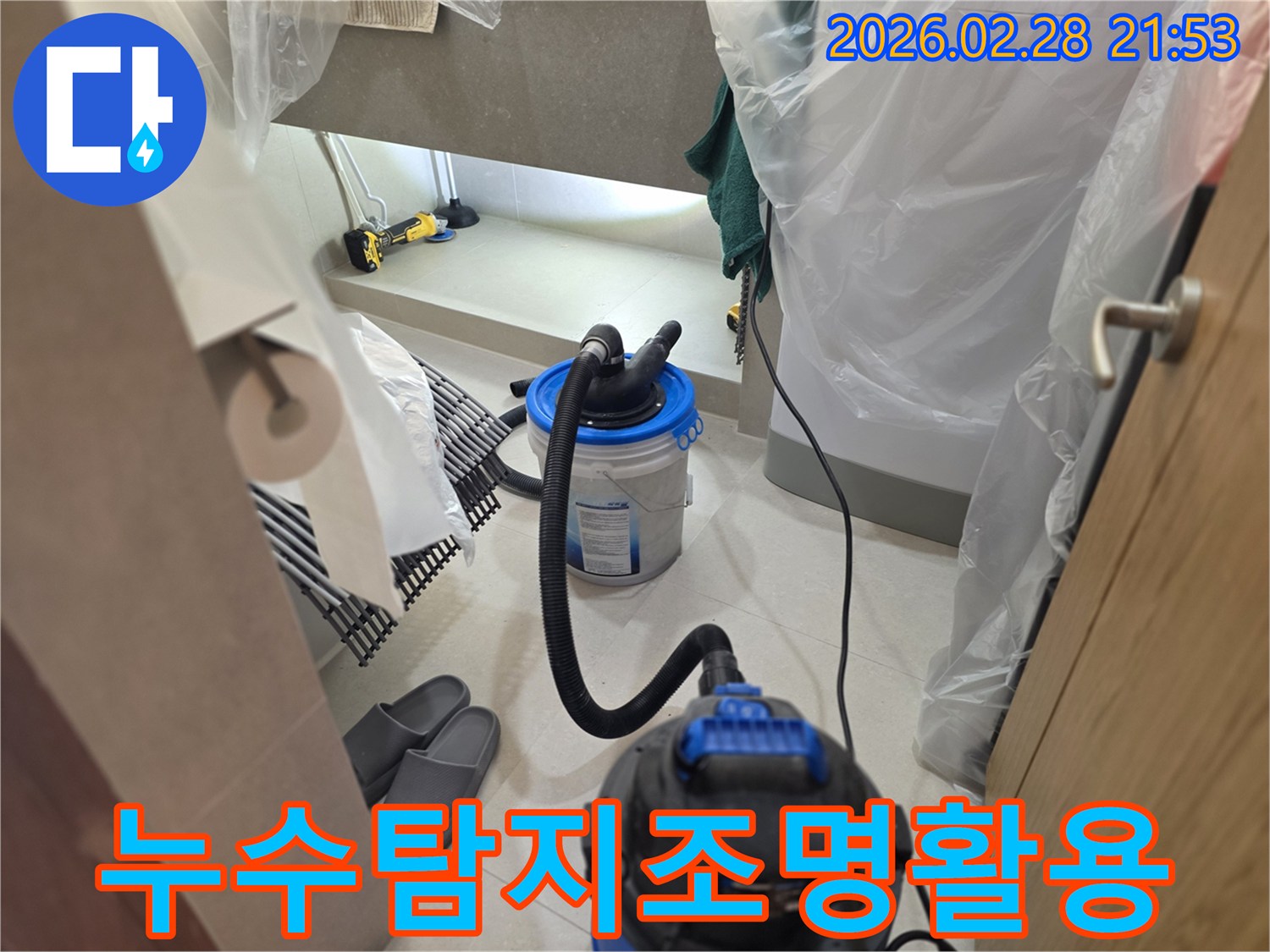 이 이미지는 누수 탐지 시-어두운 공간을 밝히기 위해 작업등을 사용하고-주변을 비닐로 보양하며-습식 청소 장비를 준비하는 현장을 보여줍니다.