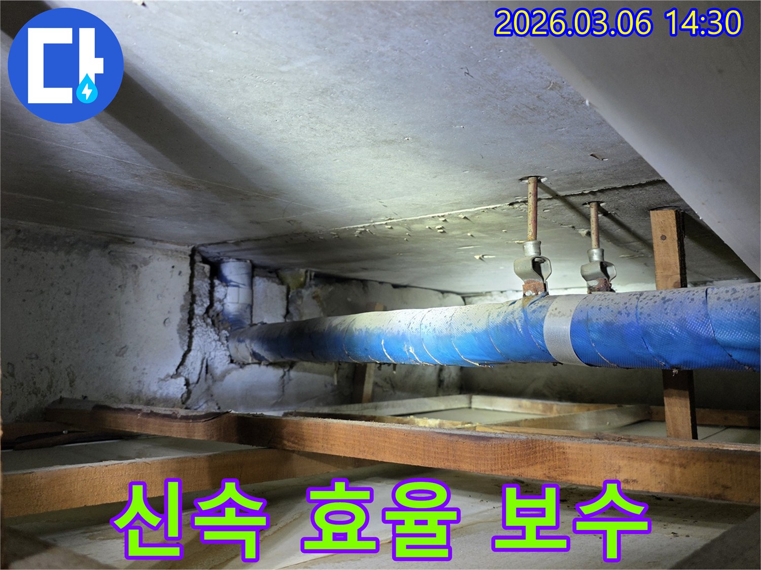 지하 공간의 파란색 배관과-손상된 콘크리트 벽면을-누수 엔지니어가-신속하고 효율적인 보수 작업을 위해-점검하는 모습