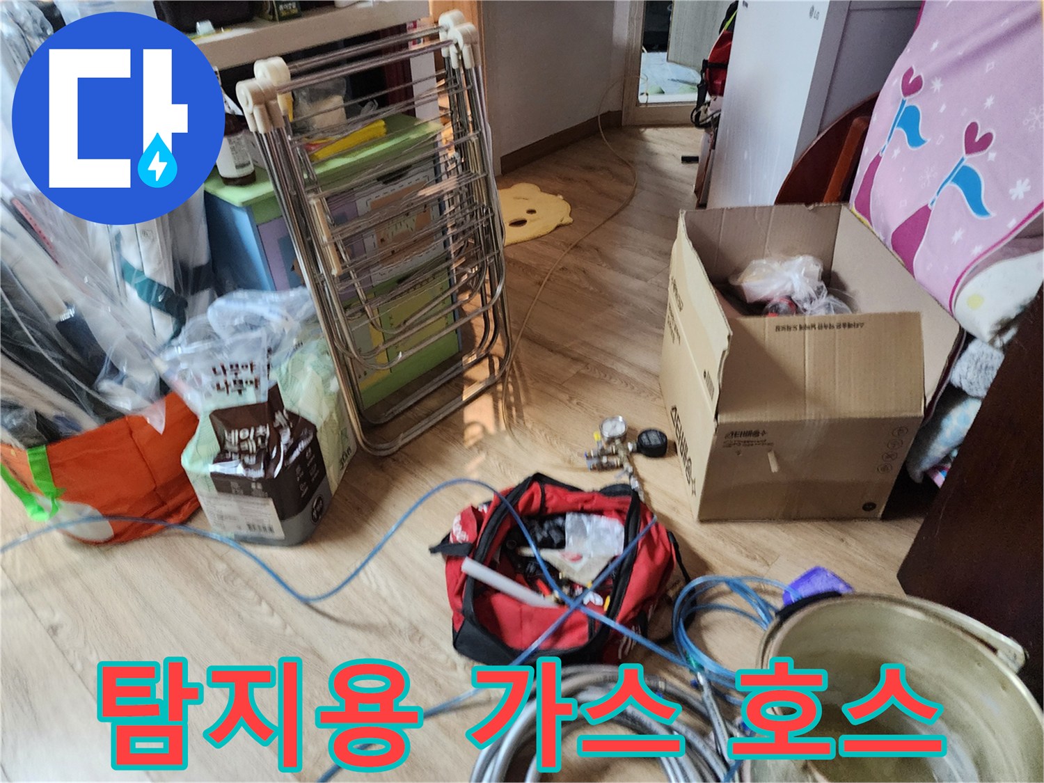 바닥에 놓여 있는 파란색 탐지 호스와 작업용 공구함