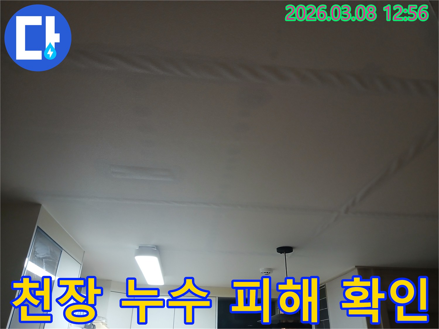 주방 천장에 물이 새어-얼룩지고 마감재가 손상된-누수 현장을 보여주는 사진
