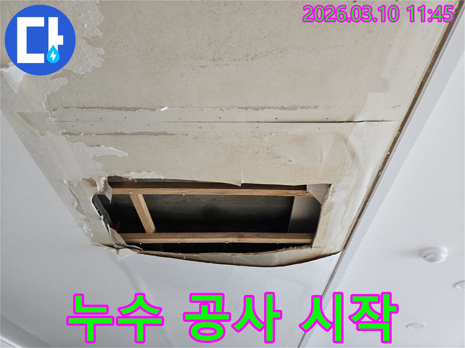 물이 새어-천장 벽지가 젖고-부풀어 오른 상태에서-내부 구조가 드러난-누수 현장입니다.