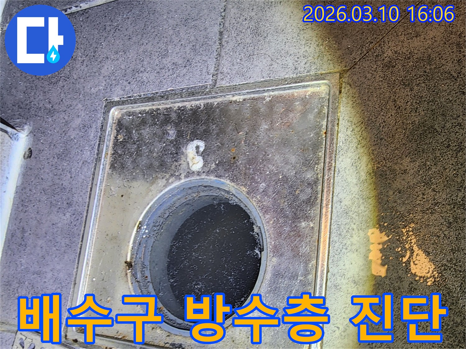 이 이미지는-서울 중구 아파트에서-배수구 주변의 방수층 손상 여부를-확인하기 위해-배수구 커버를 제거하고-내부를 점검하는-과정을 보여줍니다