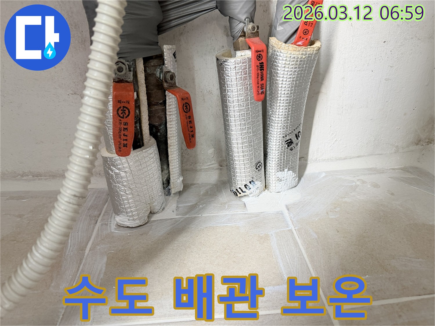 누수-공사-중-수도-배관에-보온재를-감아-동파를-예방하는-작업-현장