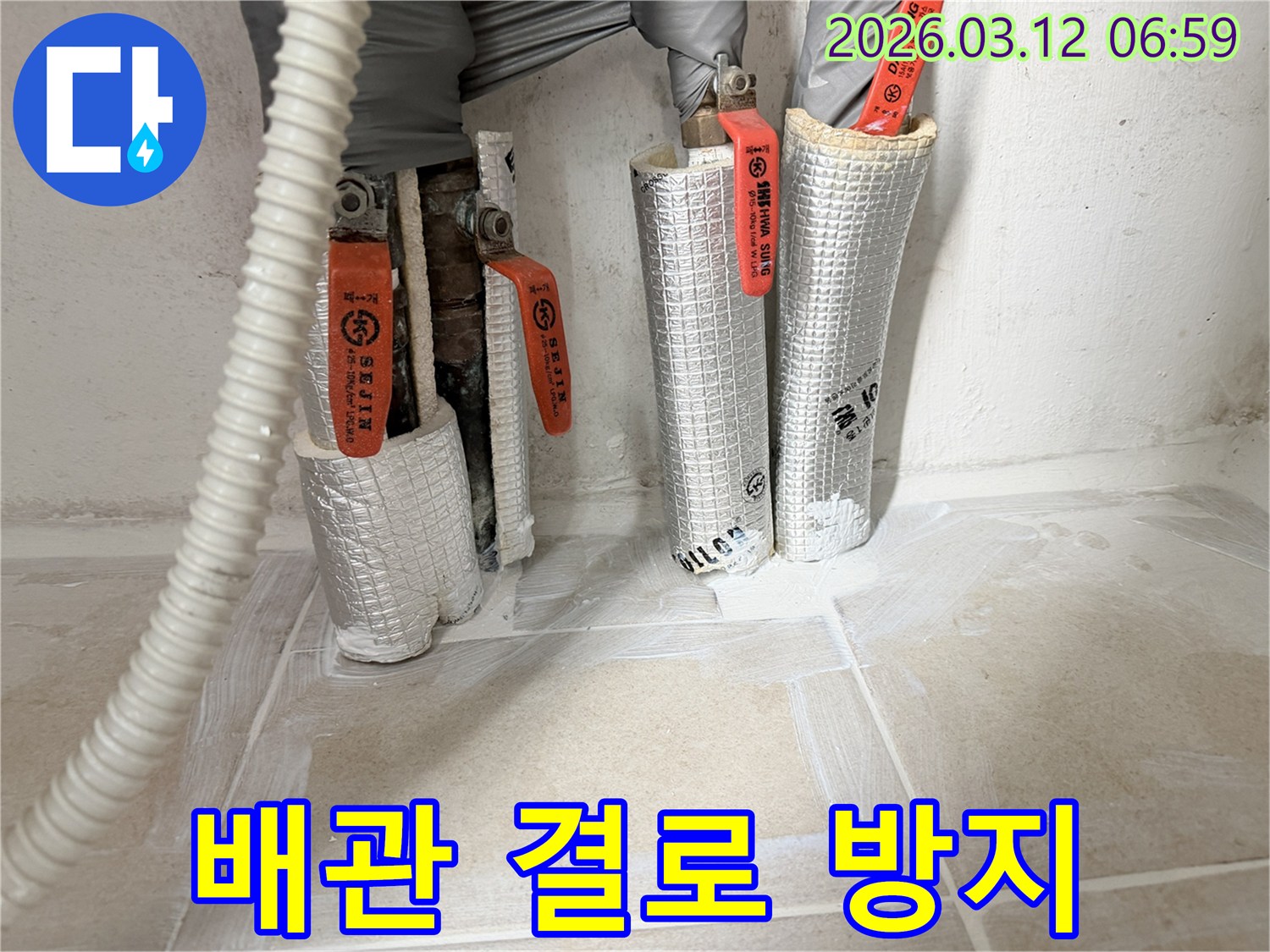 누수-공사-현장에서-배관-결로를-방지하기-위해-보온재를-꼼꼼하게-시공하는-모습