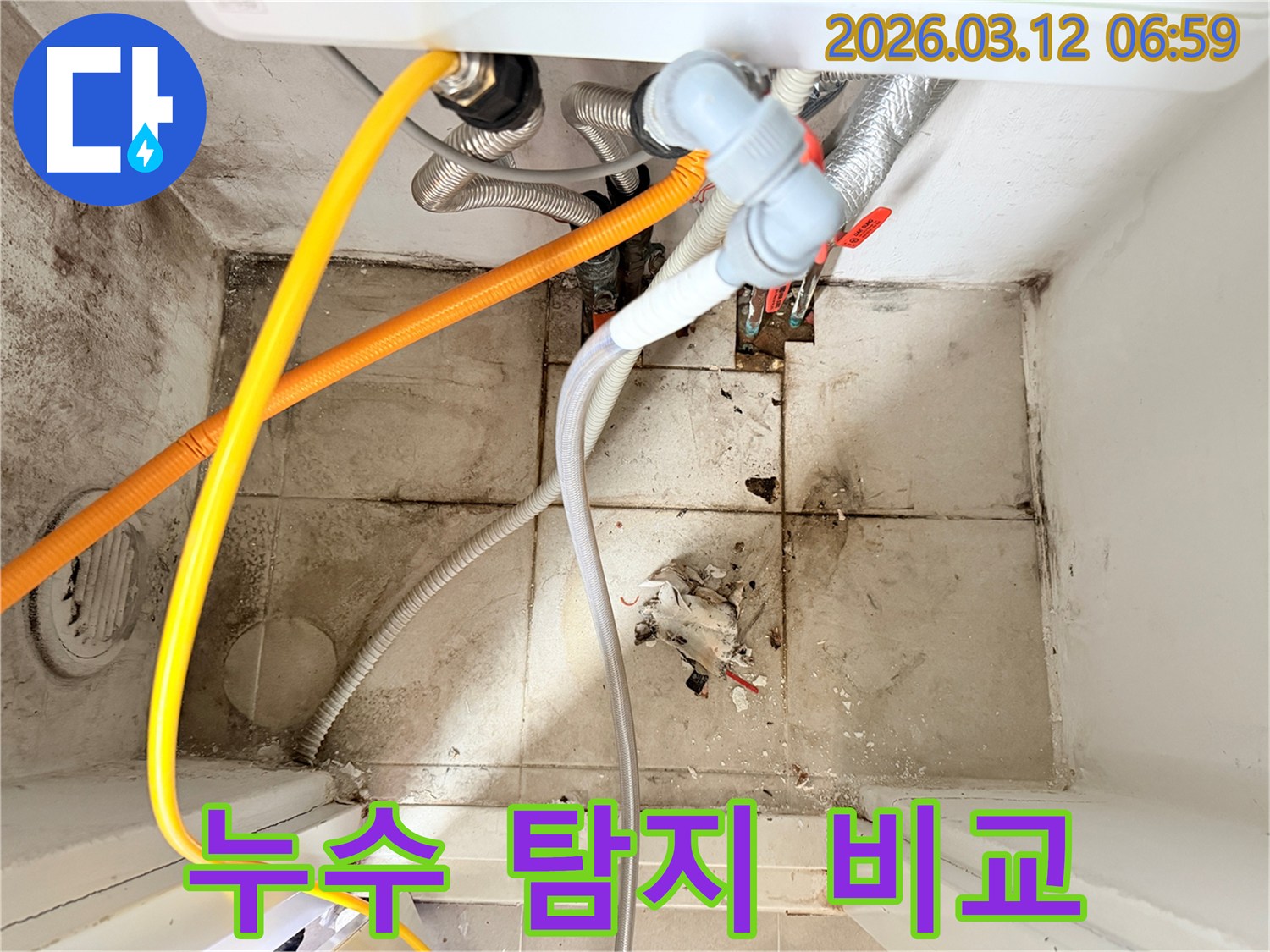 복잡하게 얽힌 배관들과-오염된 바닥 타일이-누수 발생 현장의-심각성을 보여줍니다.