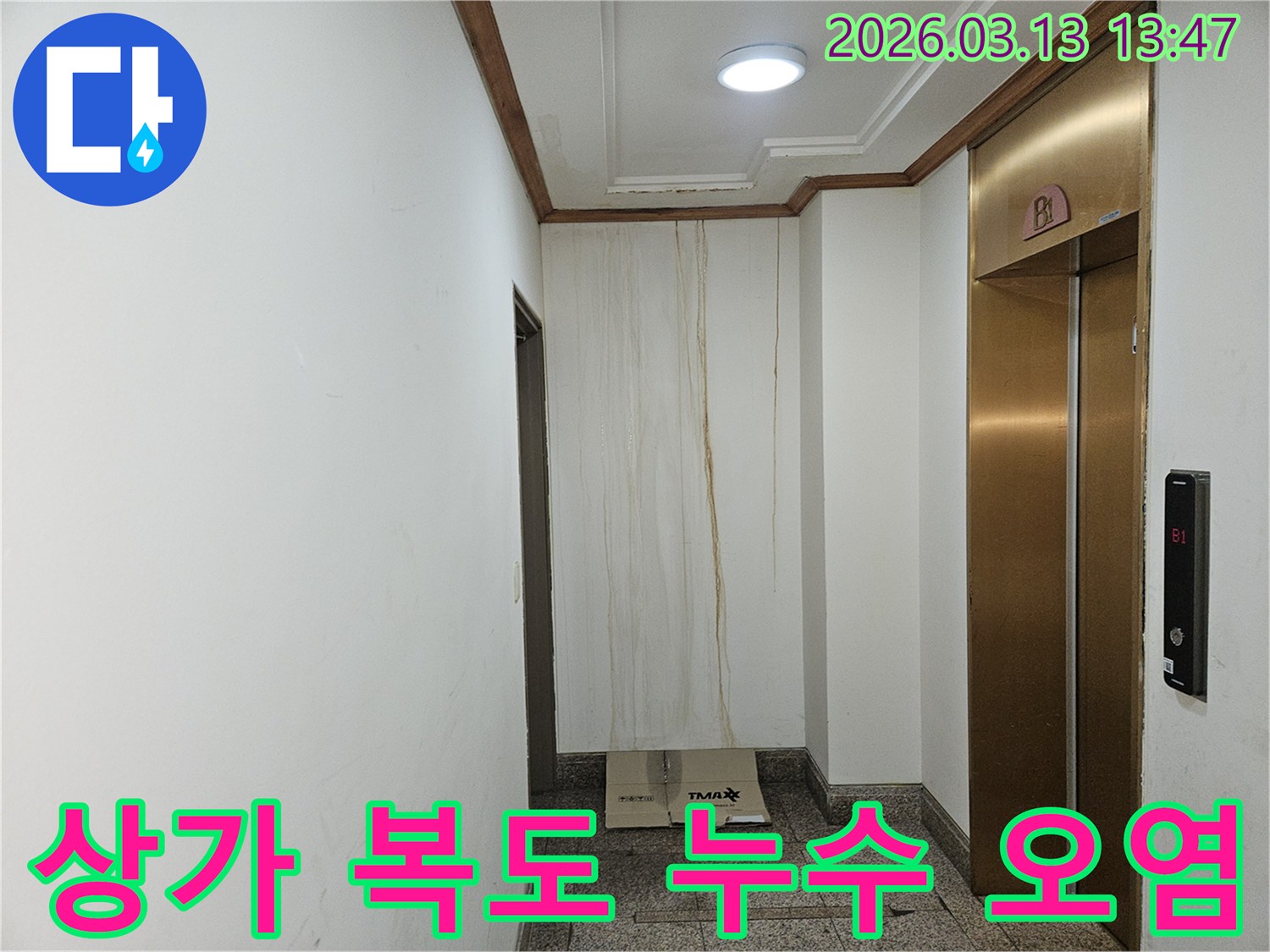 이 사진은 상가 복도 벽면에 발생한 누수로 인해-물이 흘러내려 심하게 오염된 모습을 보여줍니다-천장과 벽의 경계에서 누수가 시작된 것으로 보입니다