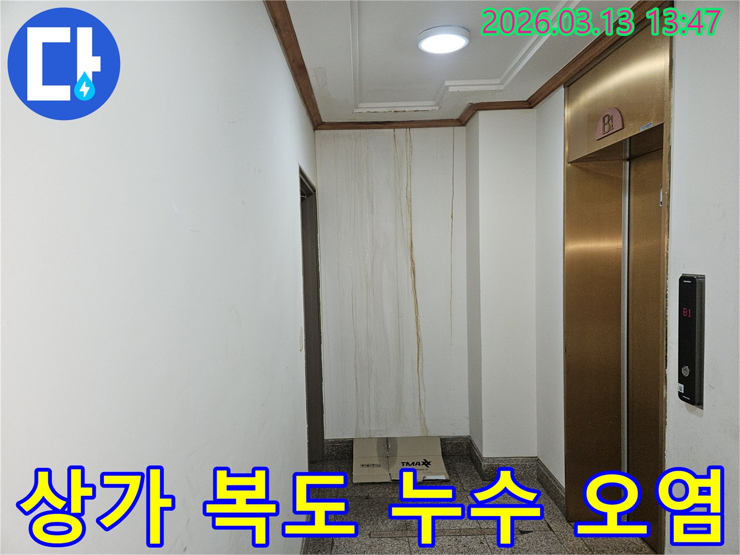 이 사진은 상가 복도 벽면에 발생한 누수로 인해-물이 흘러내려 심하게 오염된 모습을 보여줍니다-천장과 벽의 경계에서 누수가 시작된 것으로 보입니다
