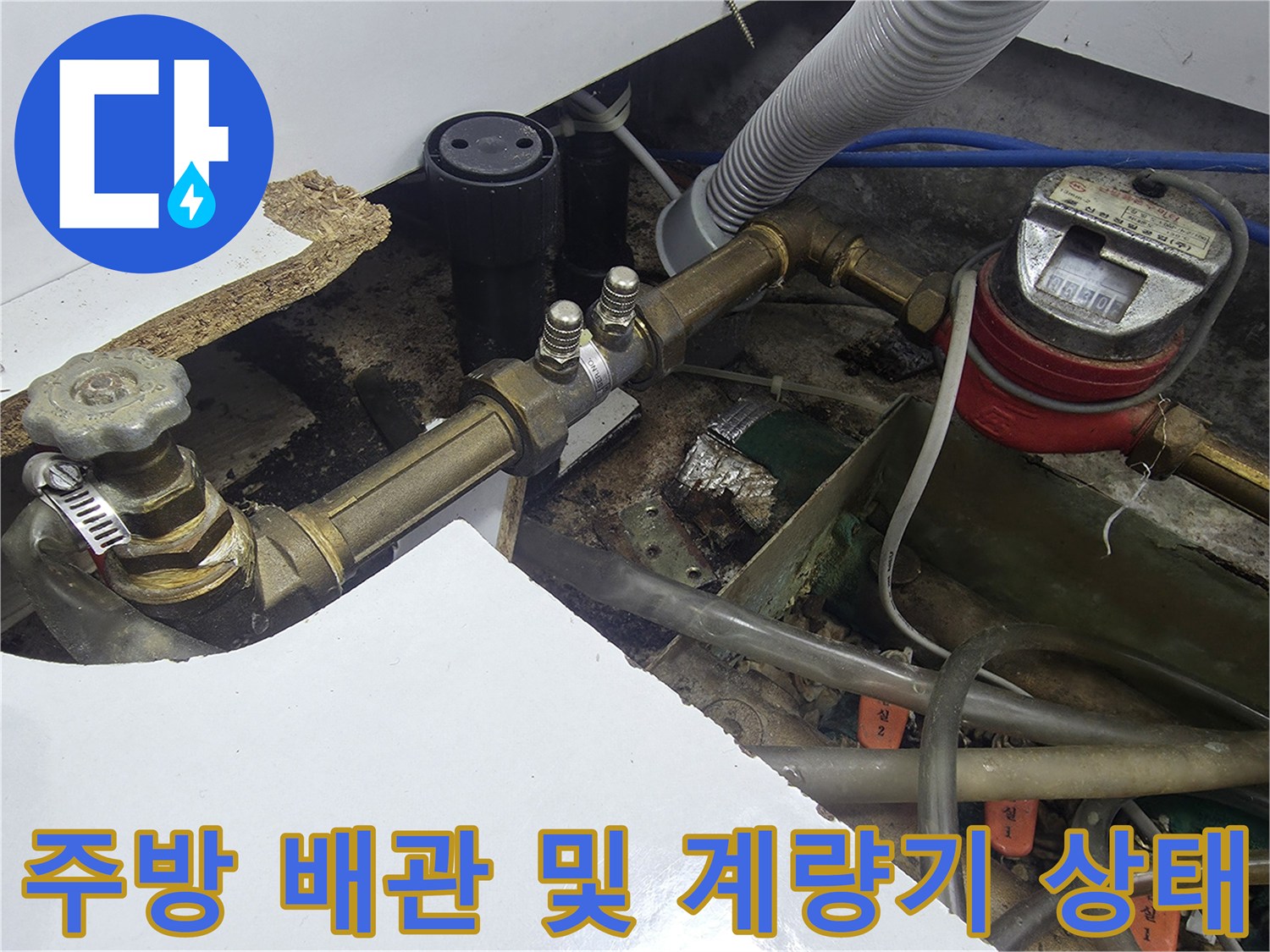 싱크대 하부의 수도 계량기와 연결된 금속 급수 배관 구조물