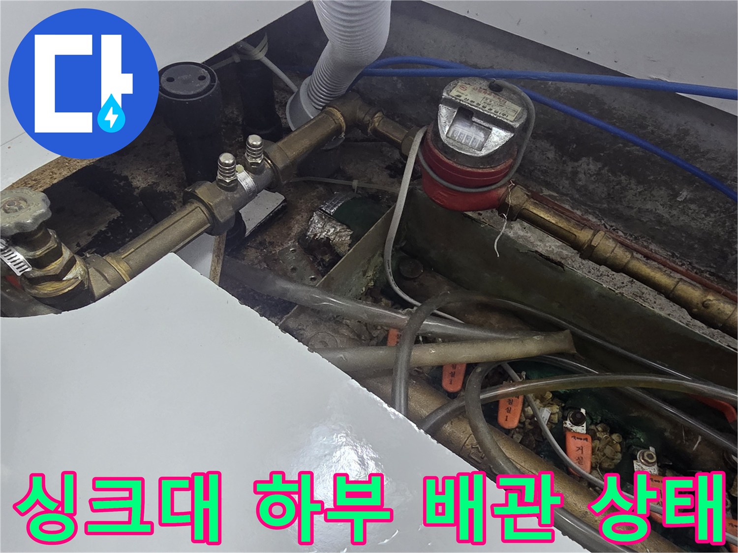 오산 운암동-주방 싱크대 아래 복잡하게 연결된 급수 배관과 계량기 모습