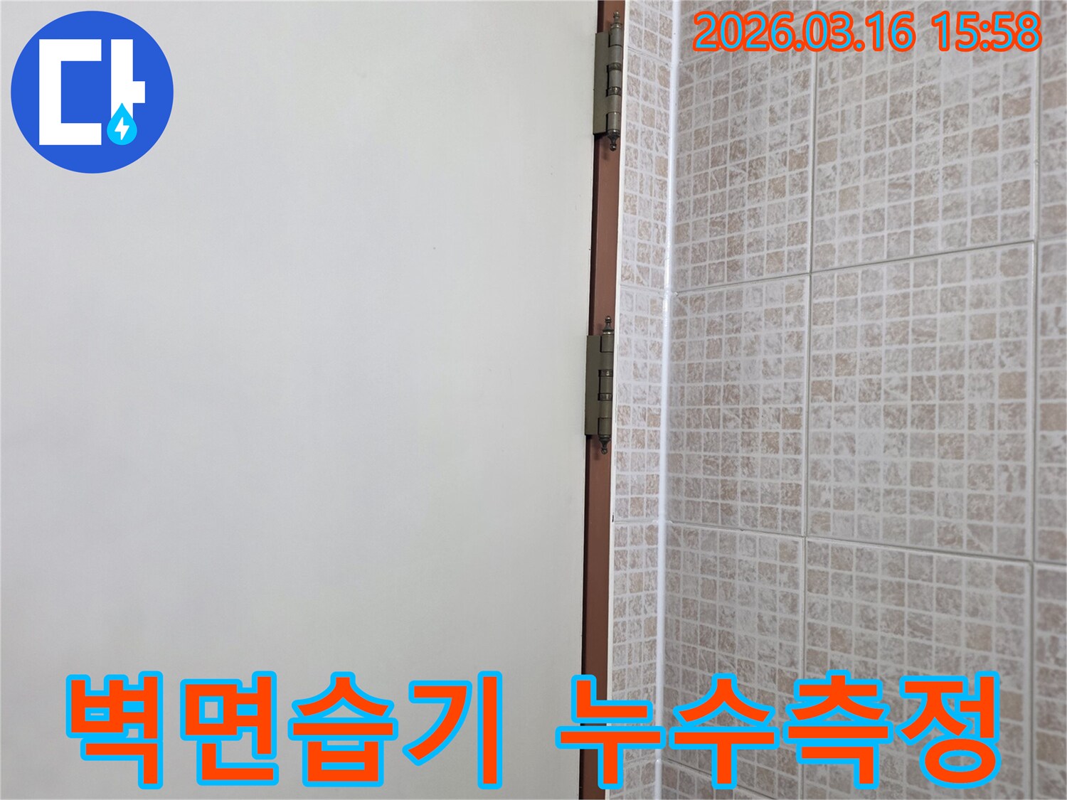 오산 운암로 아파트의 벽면과 천장 경계 부위에서-습기 측정 장비를 사용하여-누수 여부를 정밀하게 확인하는 장면입니다.