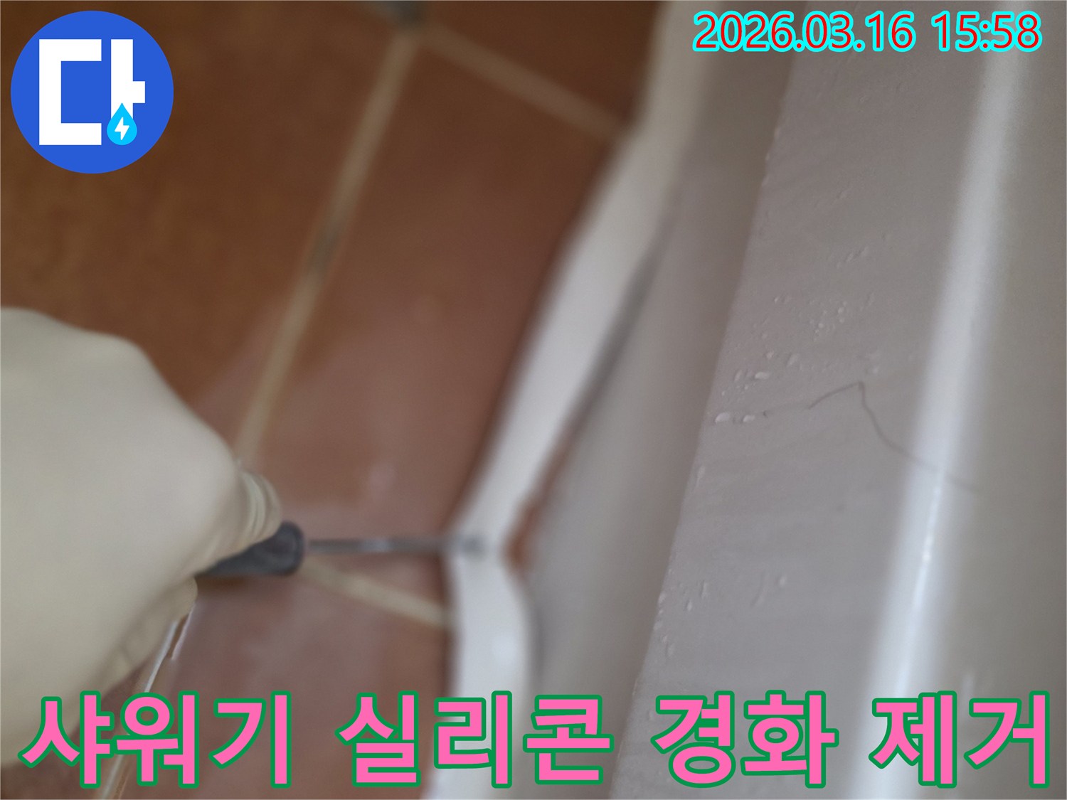 주택 샤워기 설치부의-오래되고 경화된 실리콘을-전문가가 제거하는 작업 현장