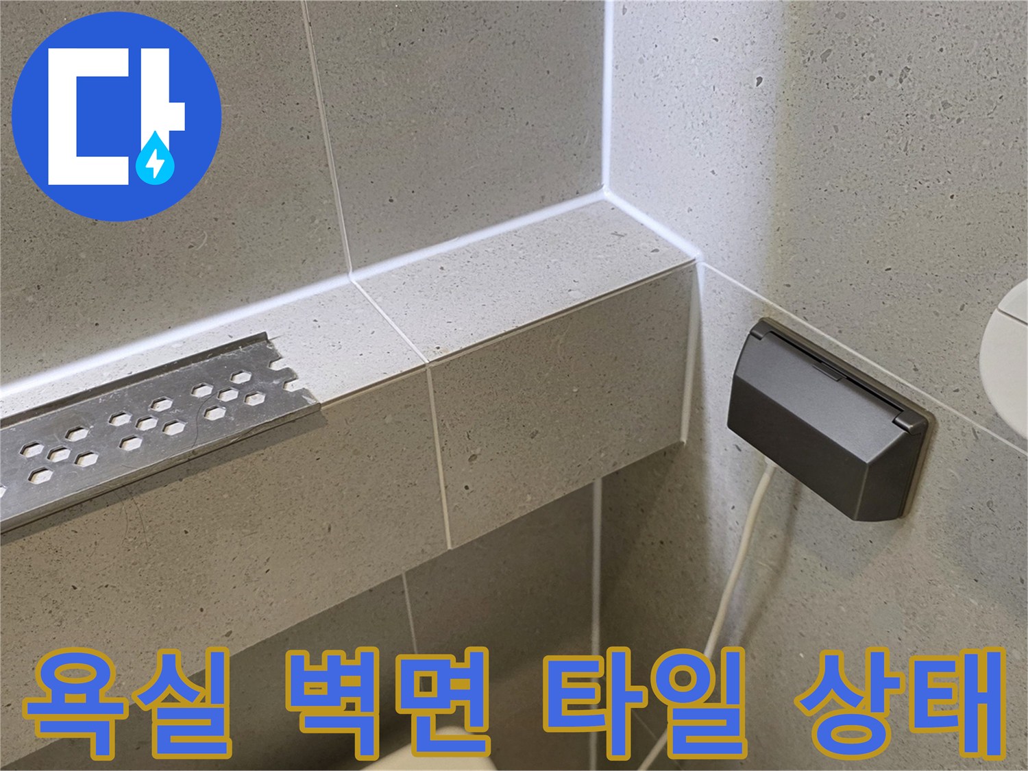 화장실 내부-배수 드레인과 전기 콘센트 근접 촬영