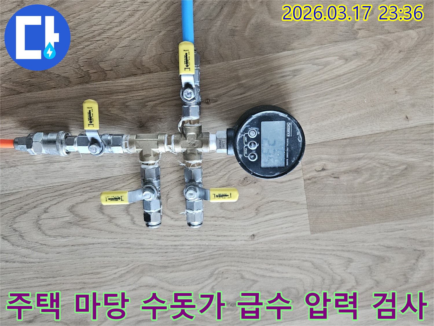 주택 마당 수돗가 급수 배관의 누수 여부를 확인하기 위해-정밀한 압력 테스트 장비를 연결하여-수치를 측정하고 있습니다.